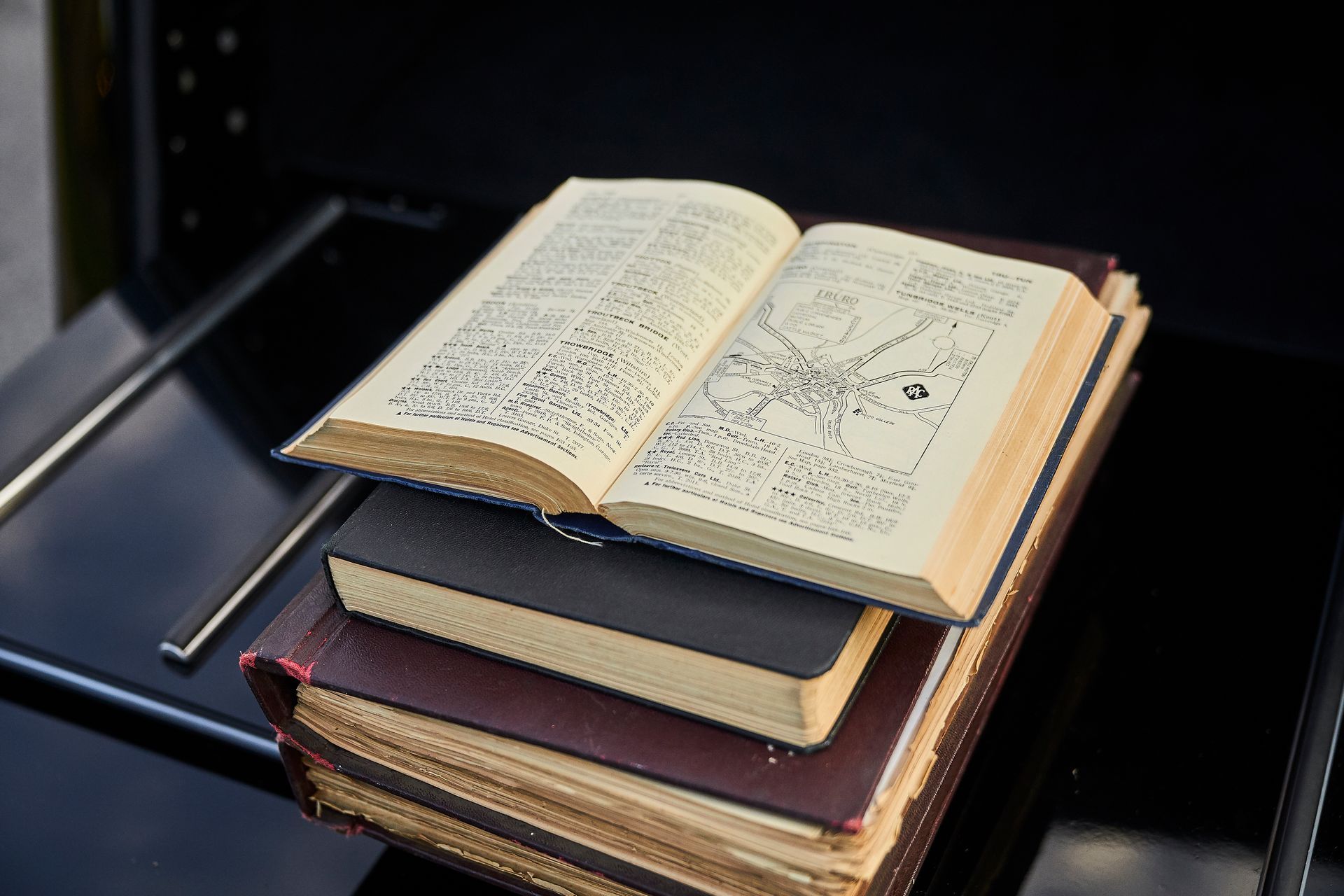 An open book is sitting on top of a stack of books.