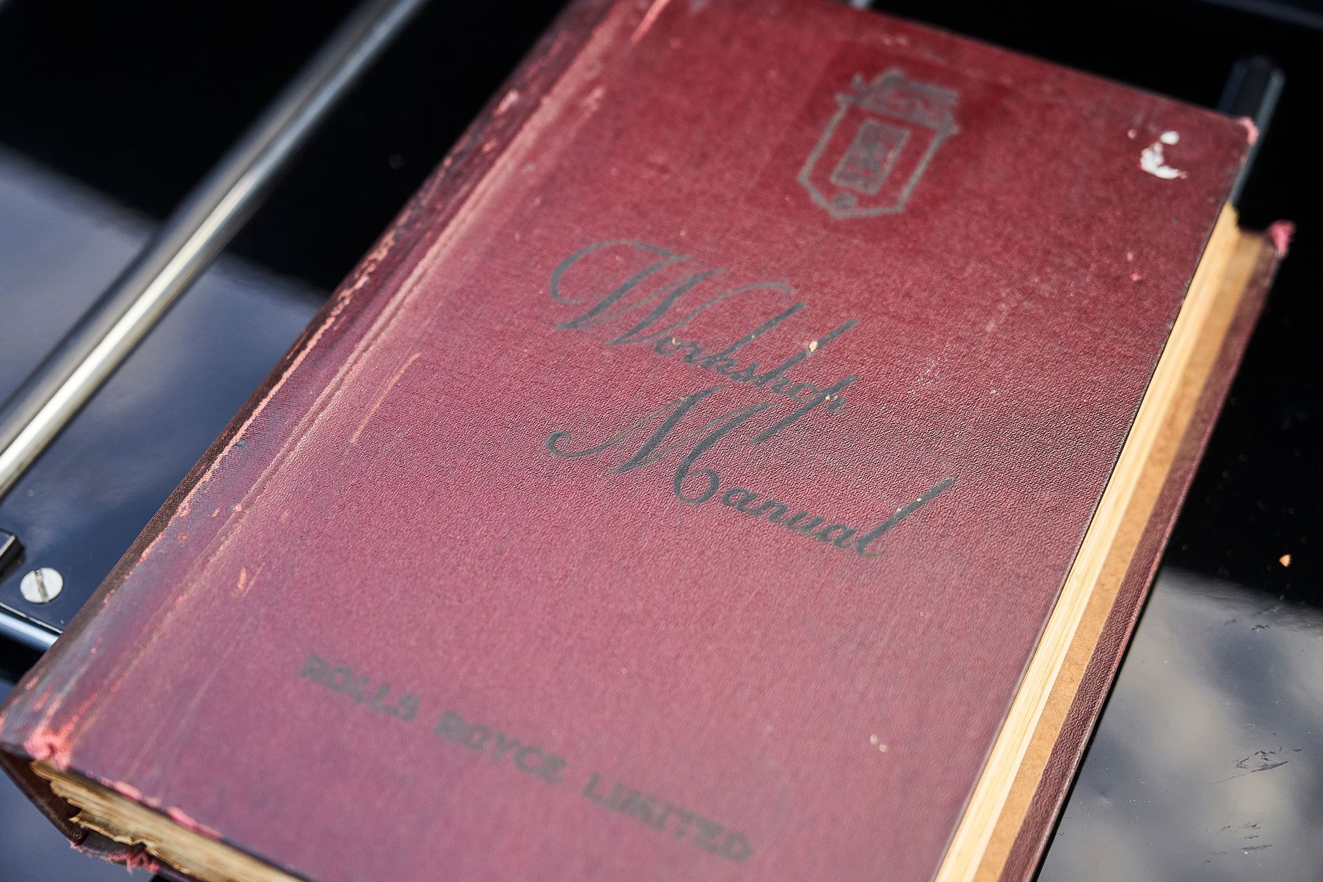 A red book is sitting on top of a black table.