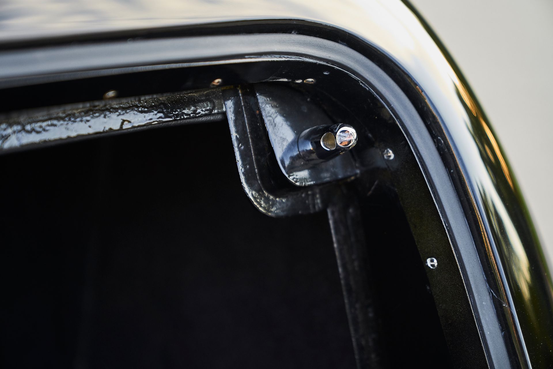 A close up of a black car with a screw in it.
