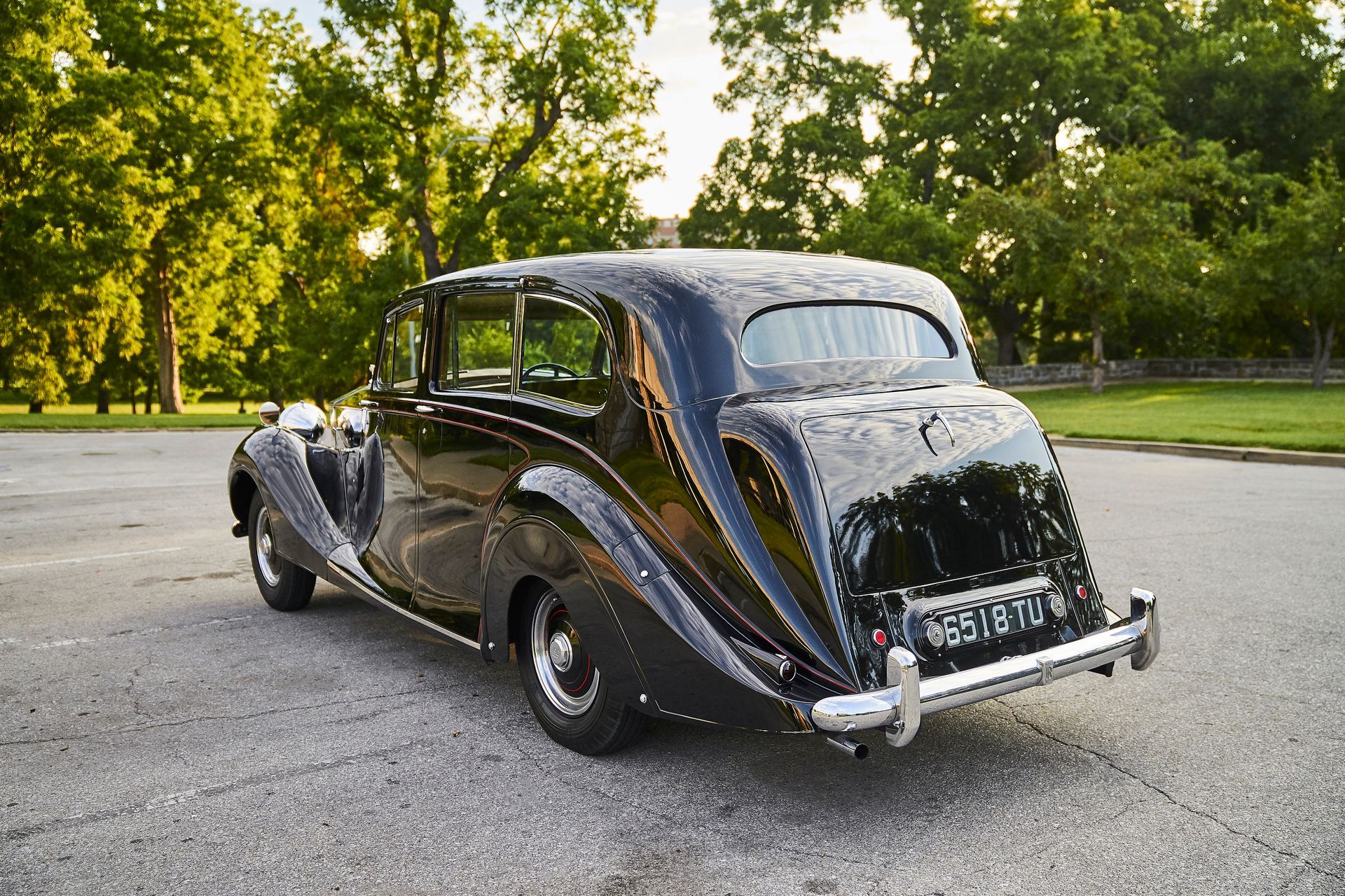 A black vintage car is parked on the side of the road.