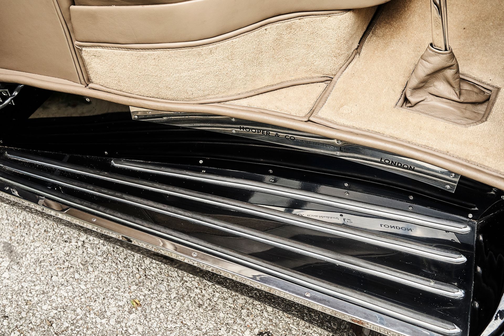 A close up of a car door with a carpeted floor