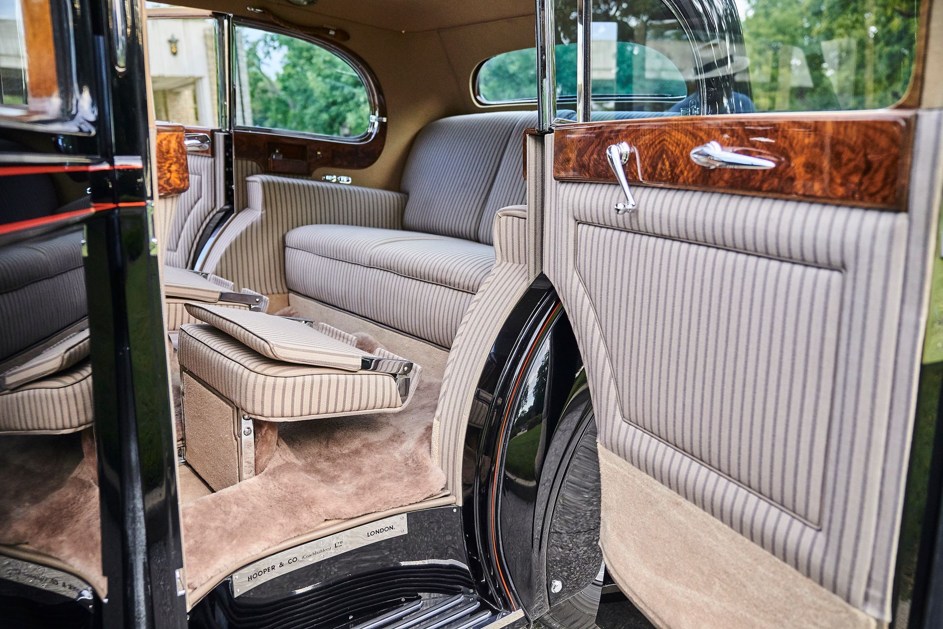The inside of an old car with a couch in the back seat.