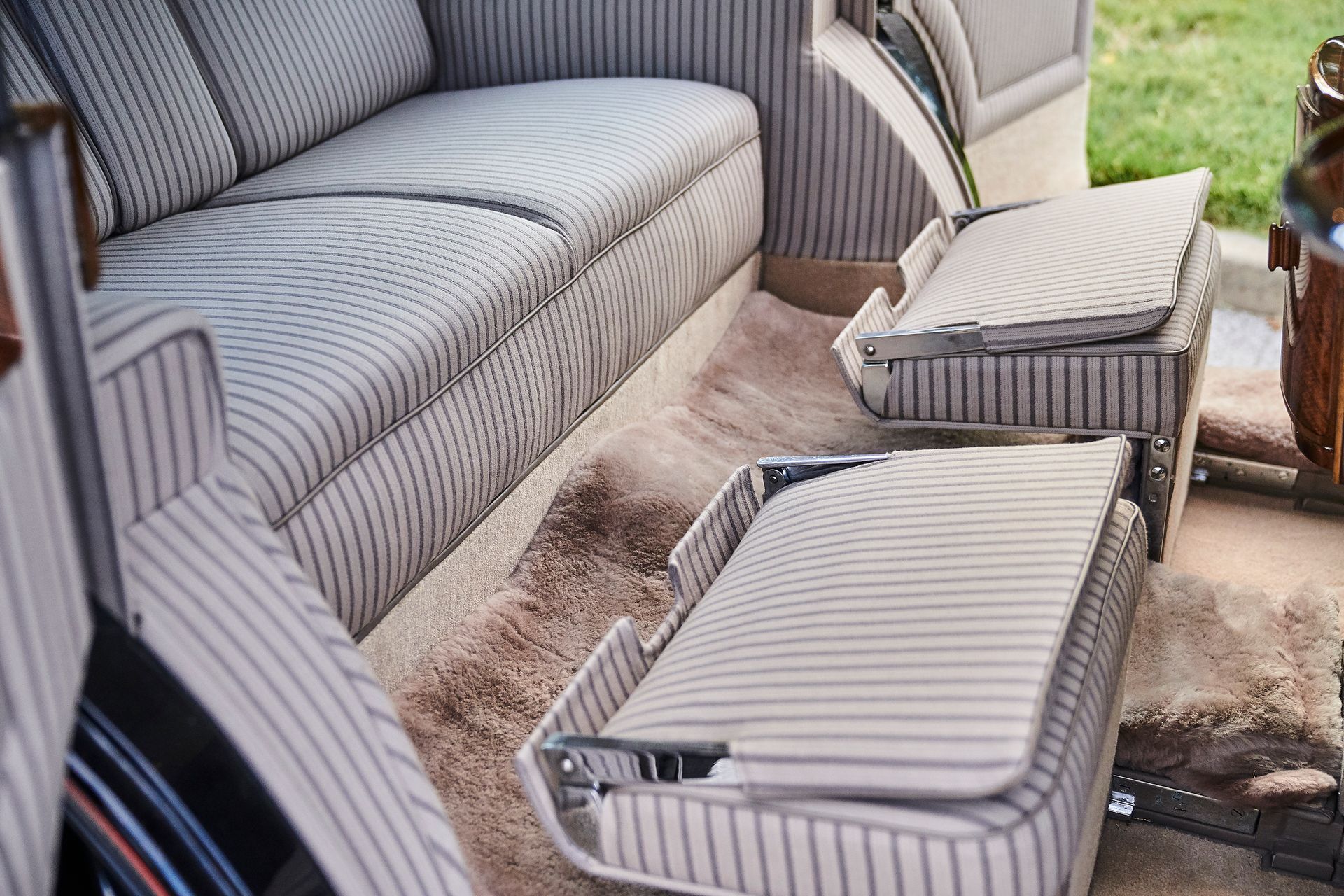 The back seat of a car with a couch and a table.