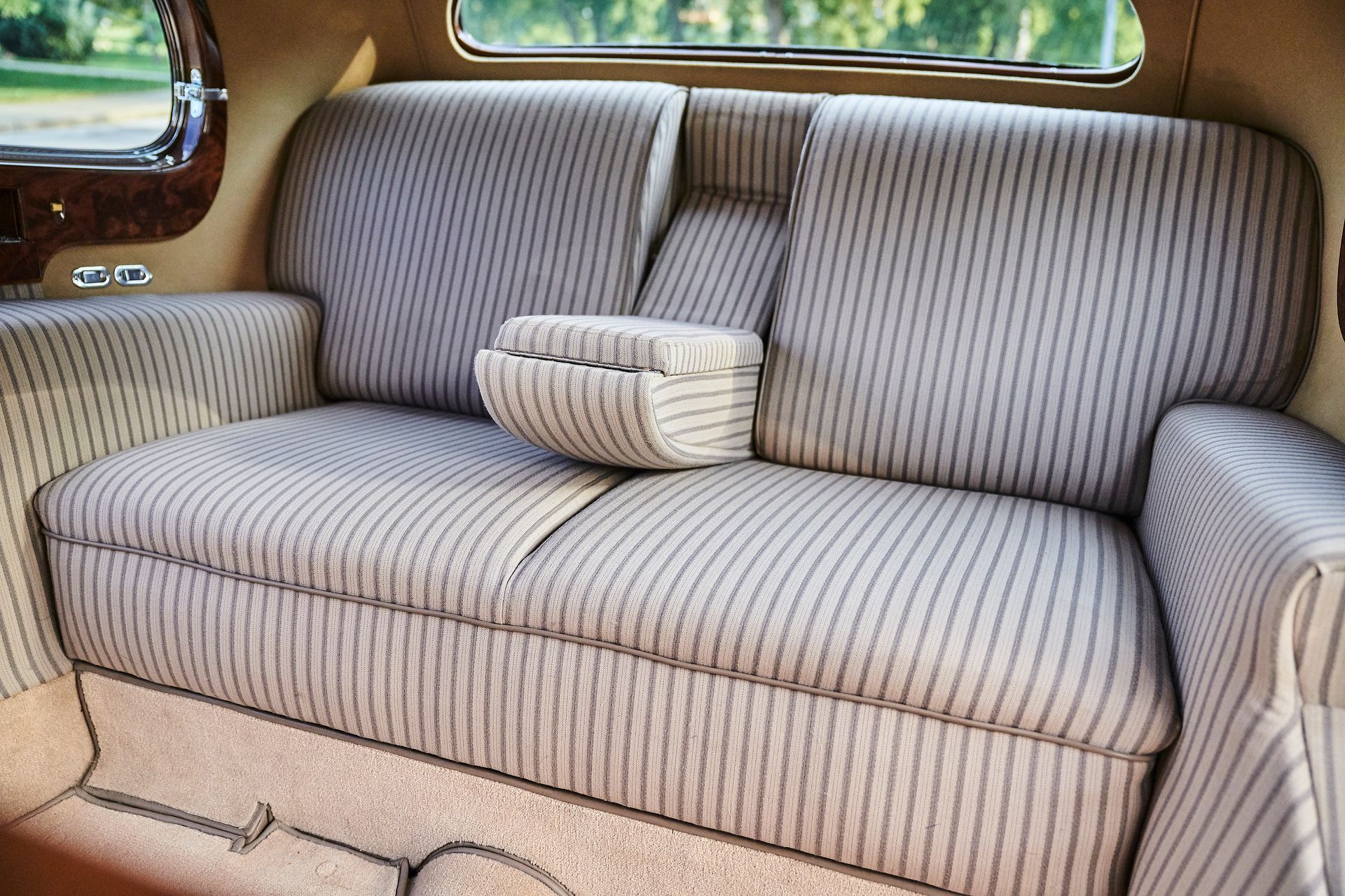 A striped couch in the back seat of a car