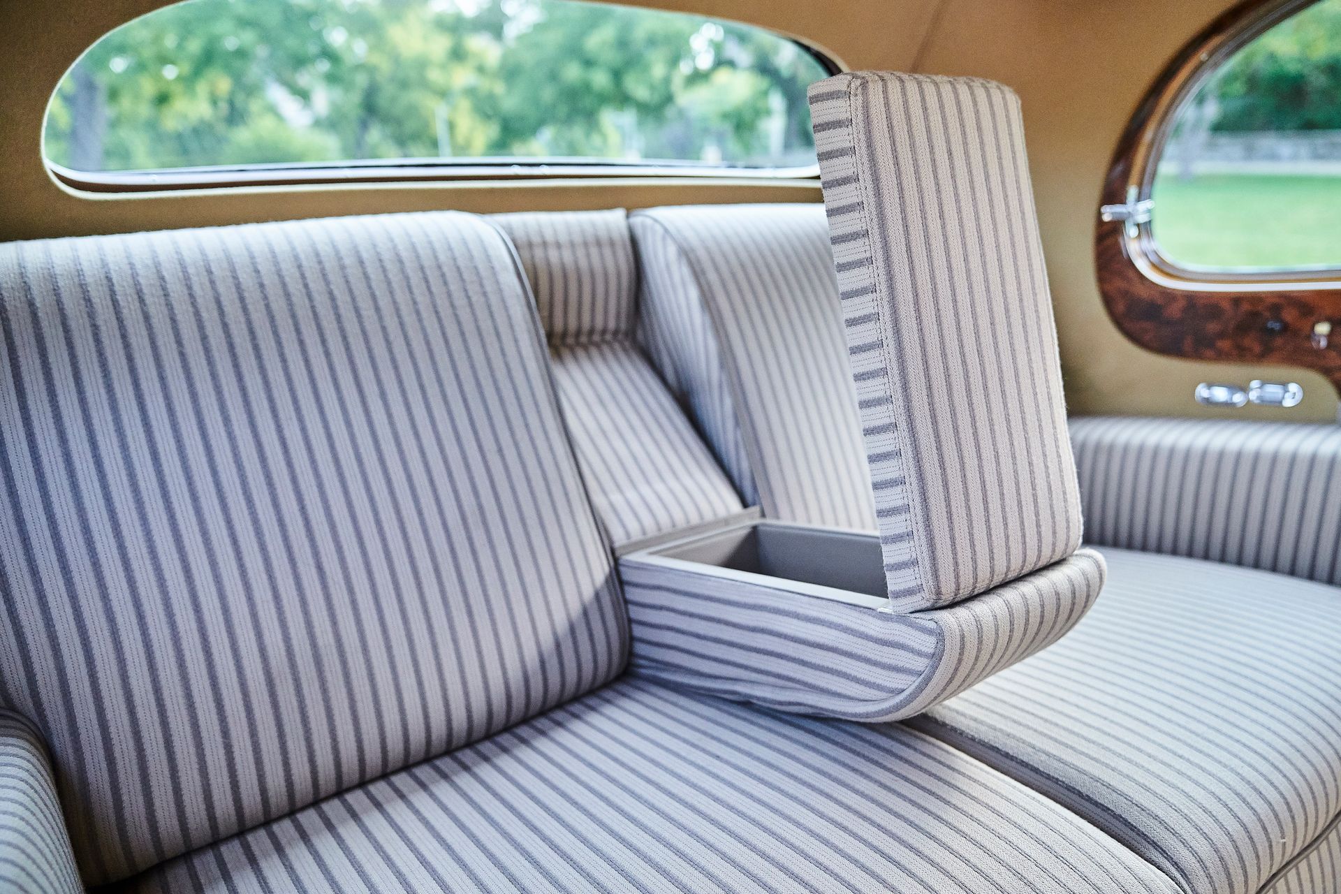 The back seat of a car with a striped couch