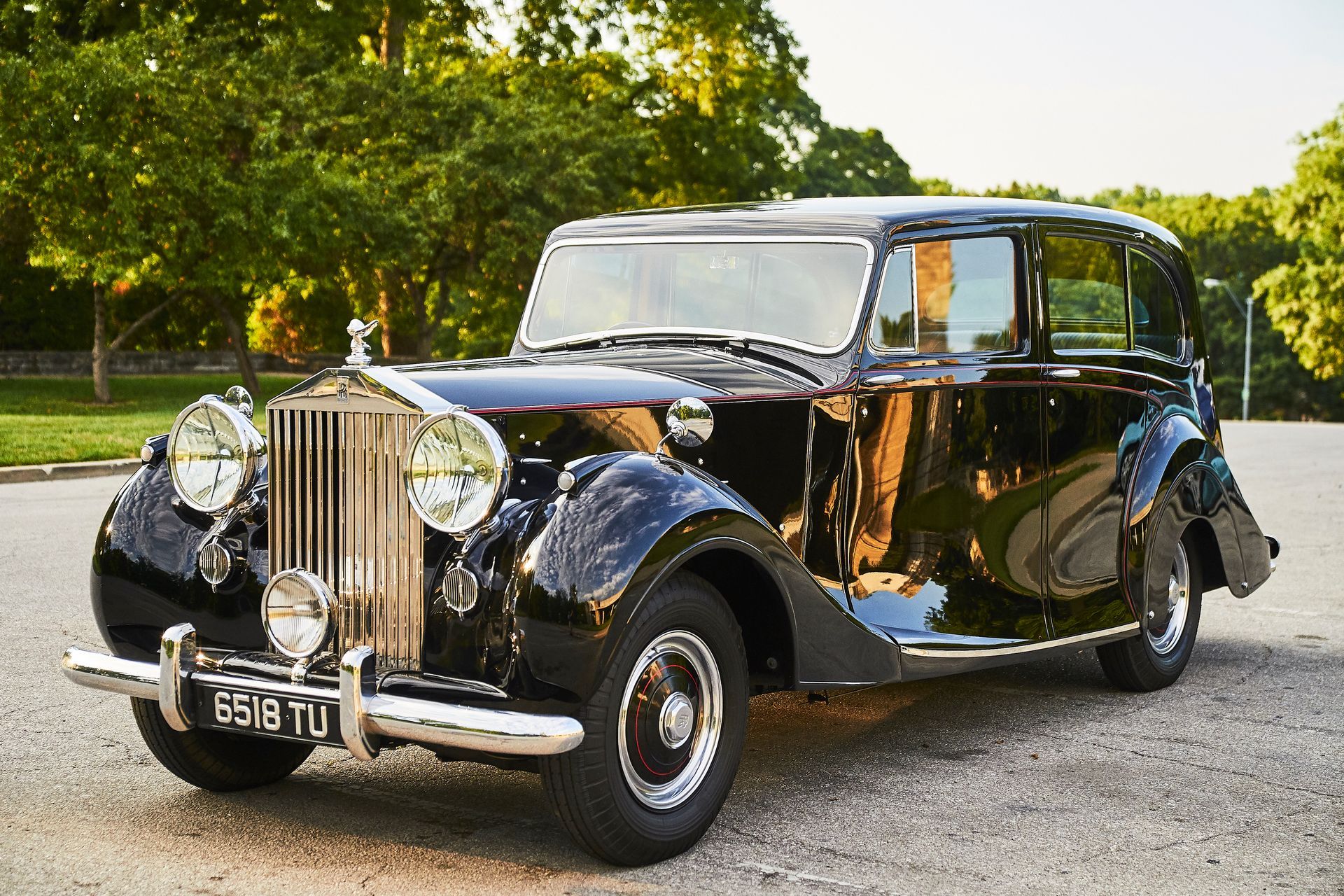 A black rolls royce is parked on the side of the road.