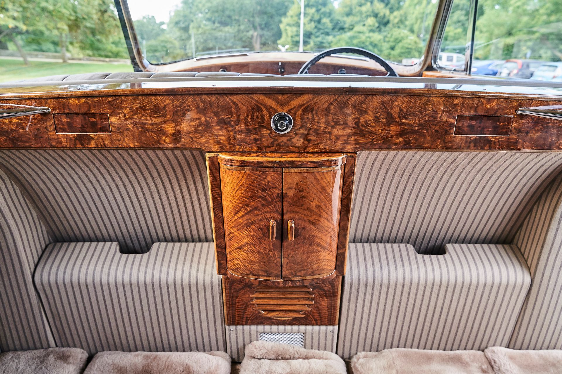 The interior of a car with a wooden cabinet and a steering wheel.