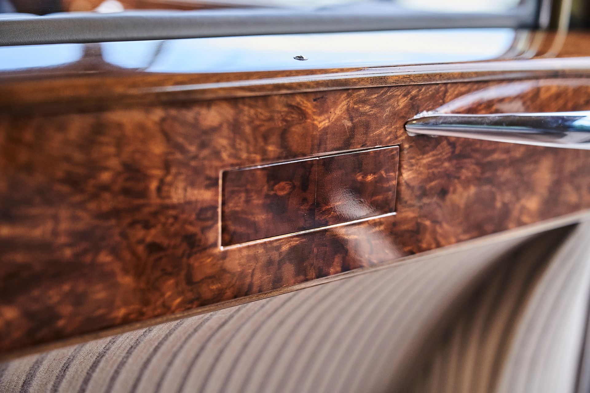 A close up of a wooden door handle on a car.