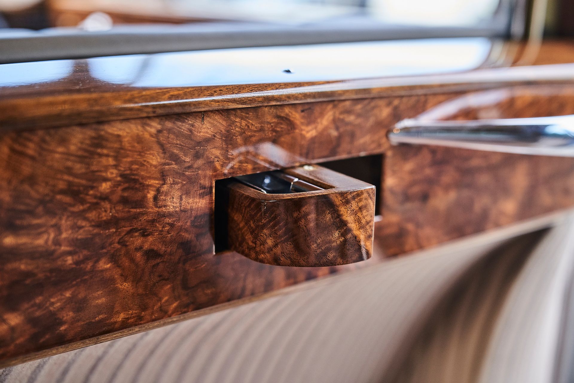 A close up of a wooden door handle on a car.