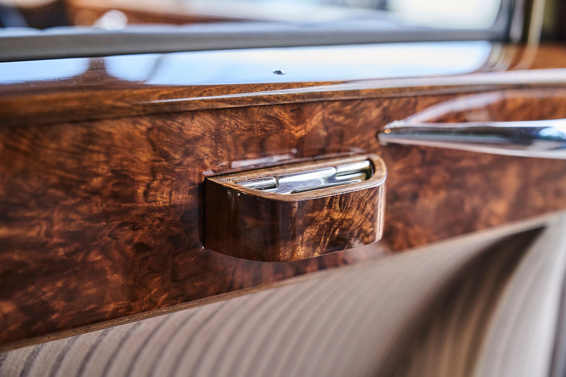 A close up of a wooden door handle on a car.