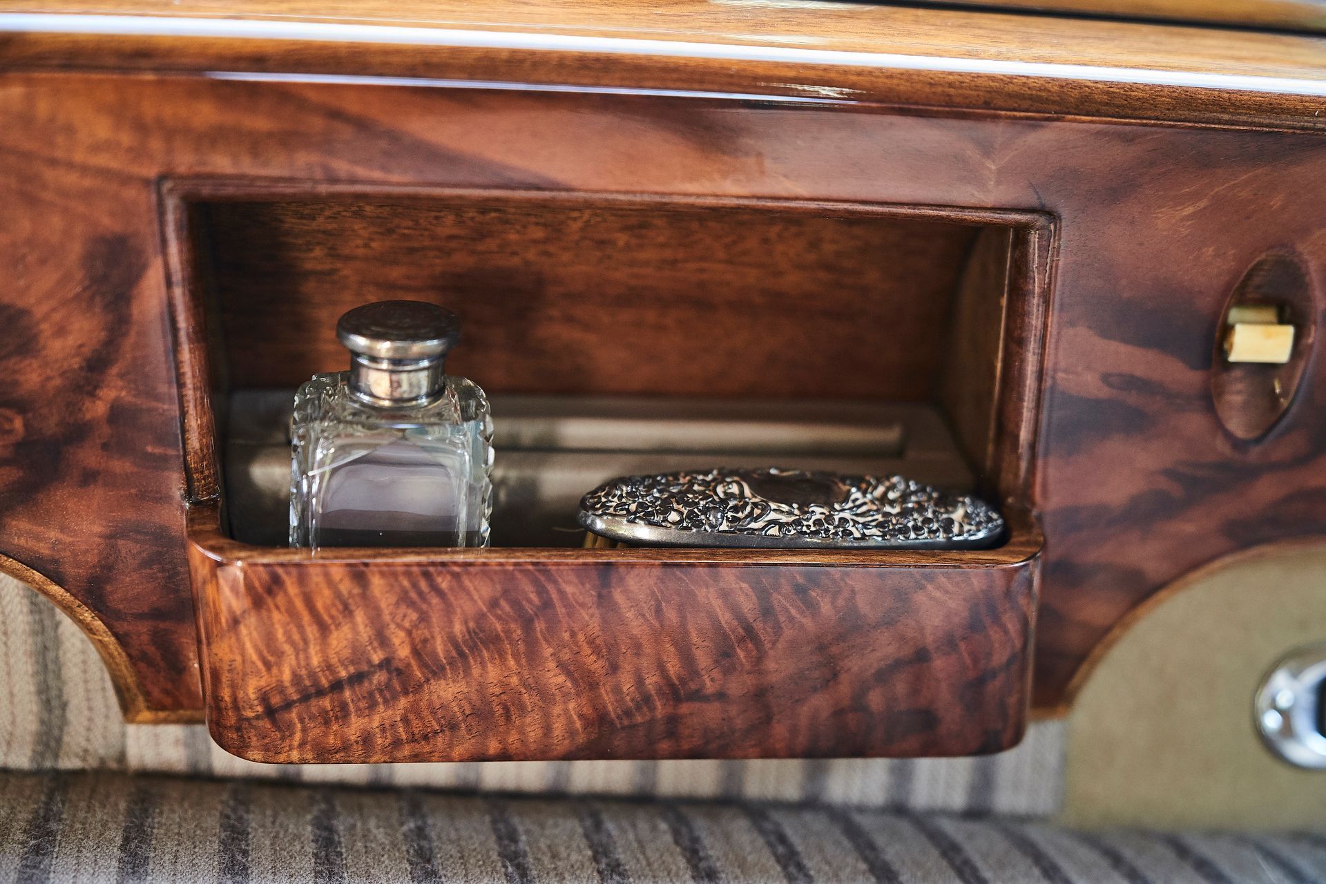 A wooden box with a bottle of perfume in it
