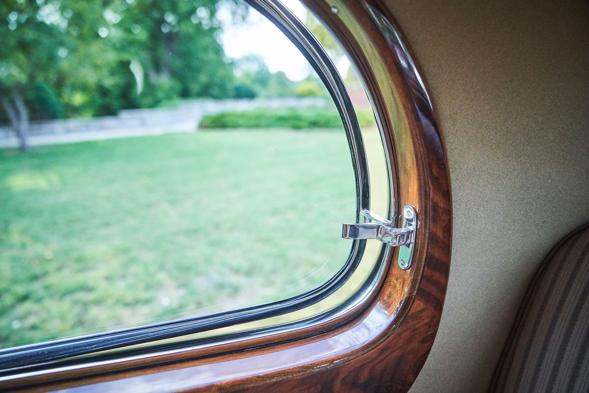 A close up of a car window with a view of a park.