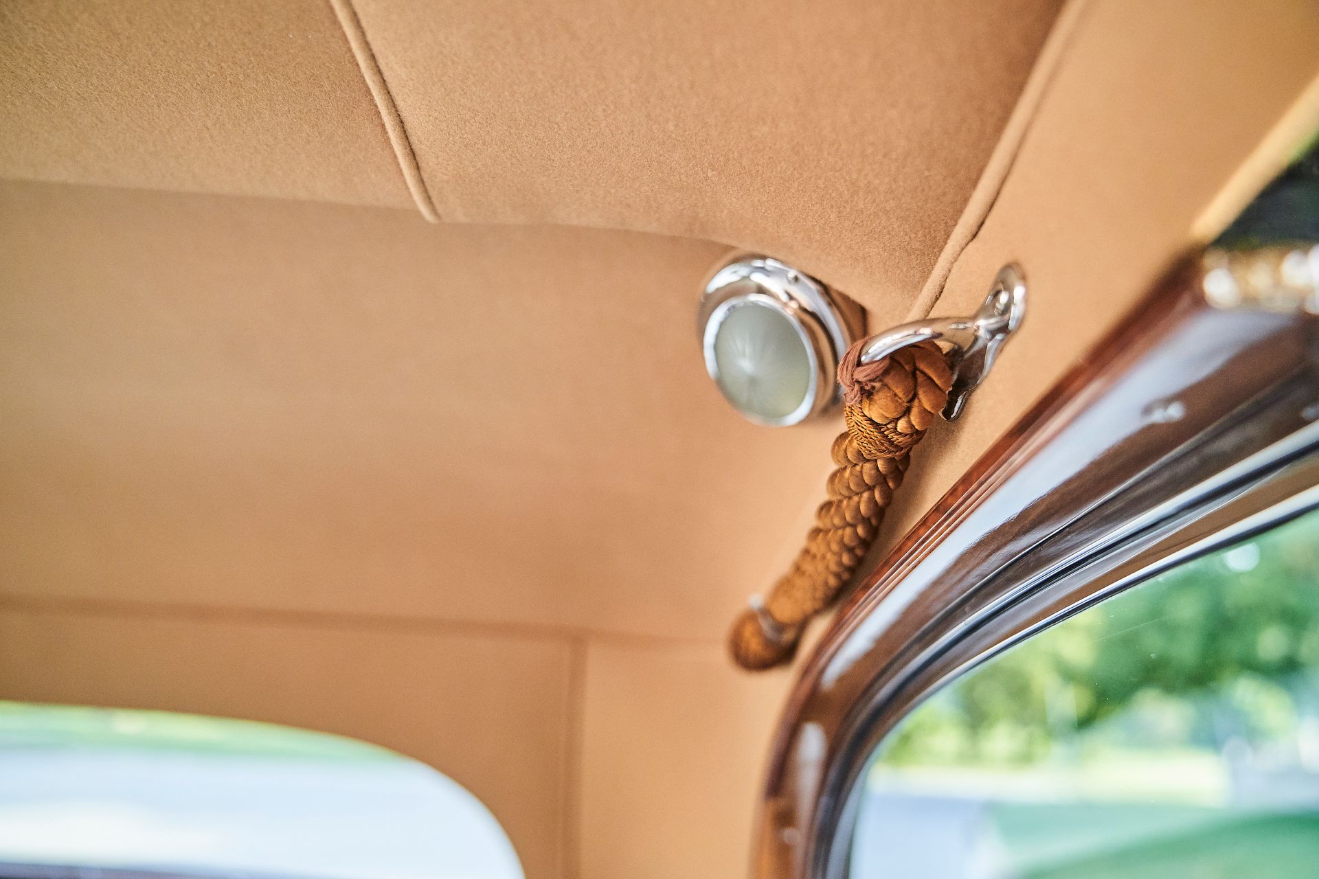 A close up of the ceiling of a car with a light hanging from it.