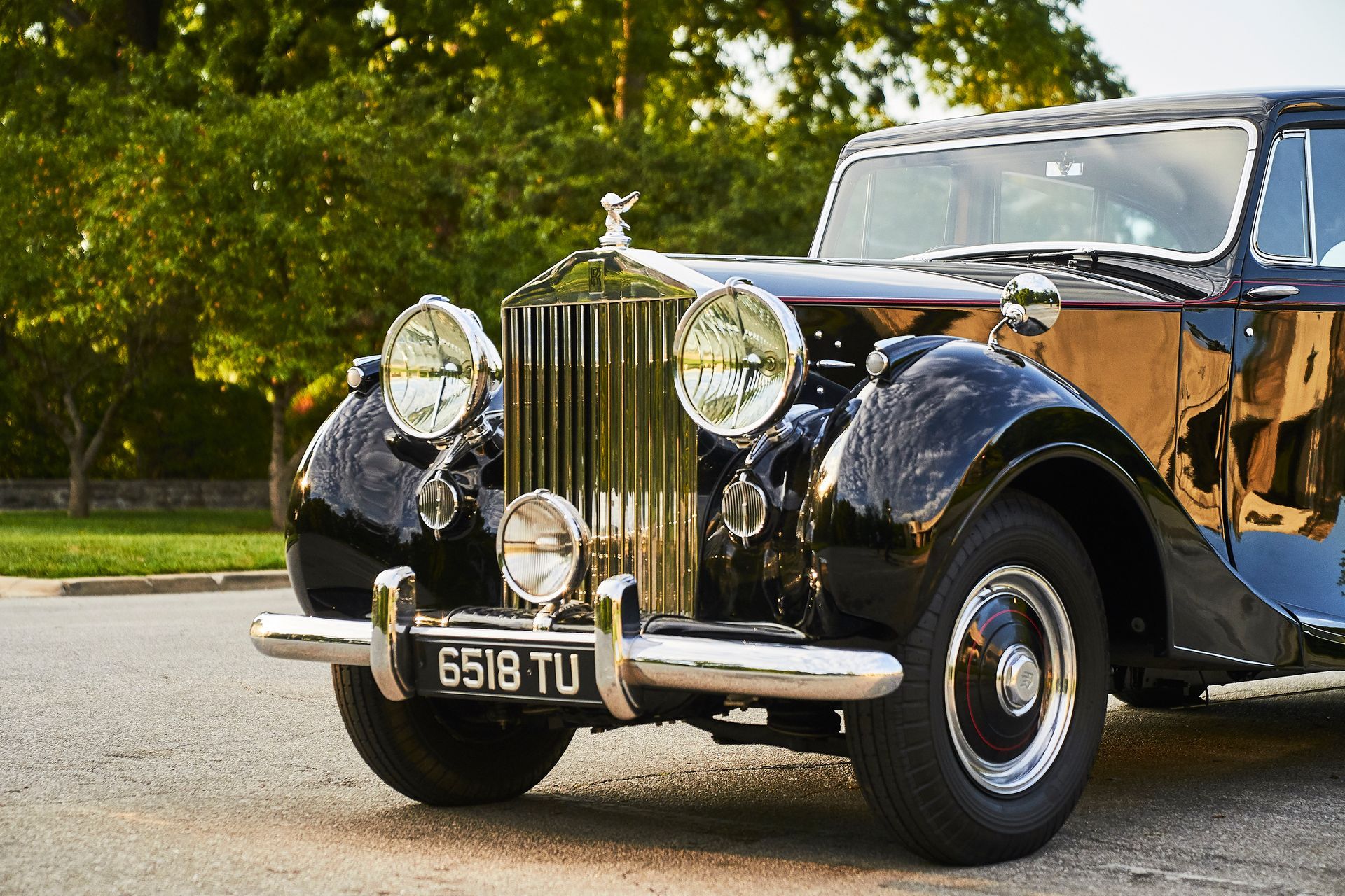 A black rolls royce is parked on the side of the road.