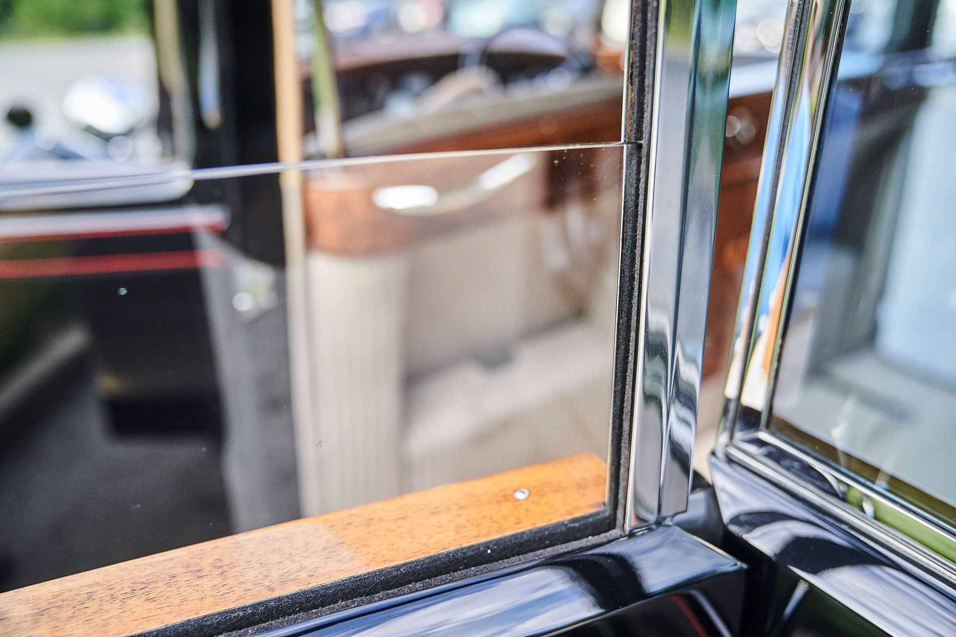 A close up of a car window with a reflection of a car in it.