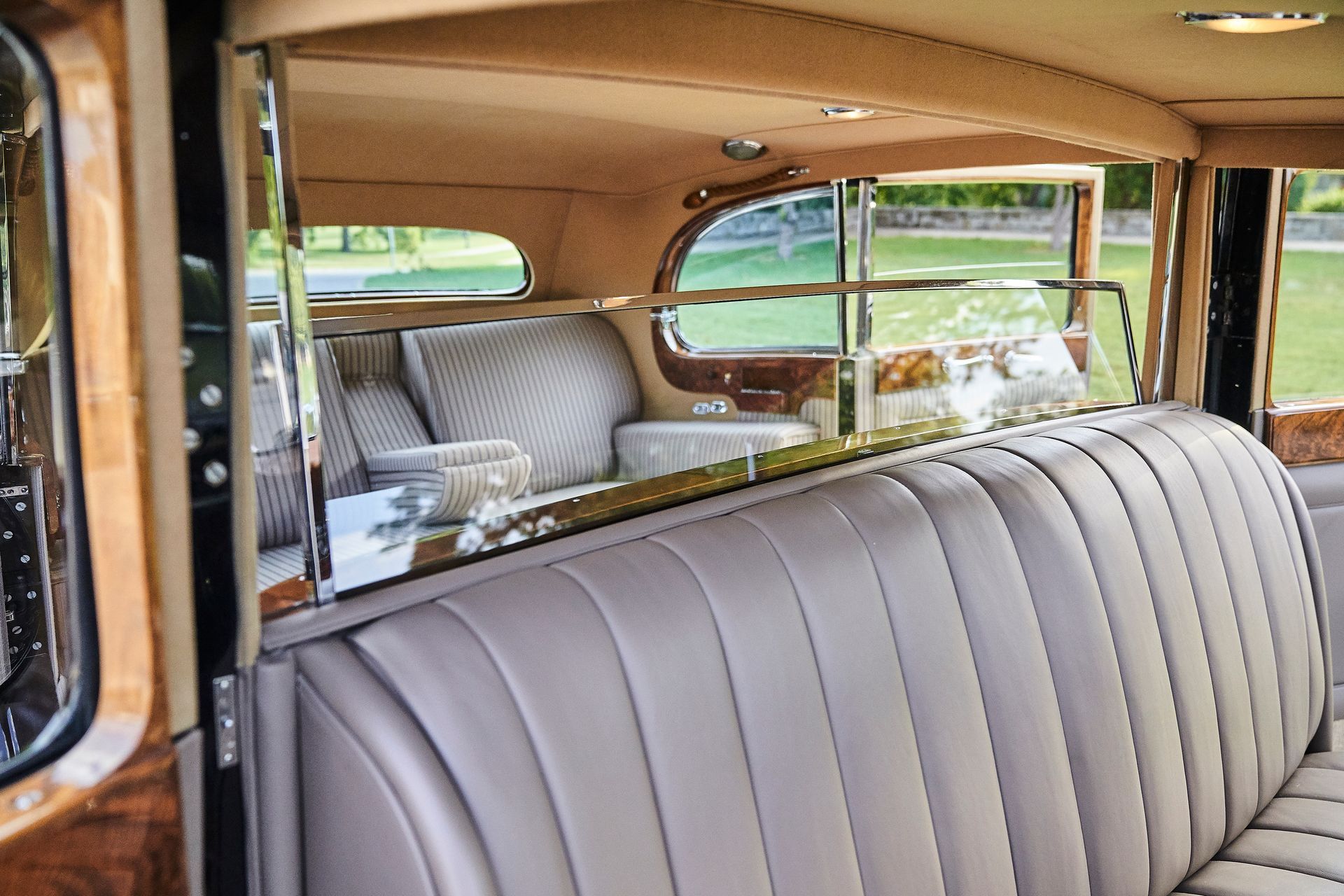The back seat of an old car with a gray leather seat