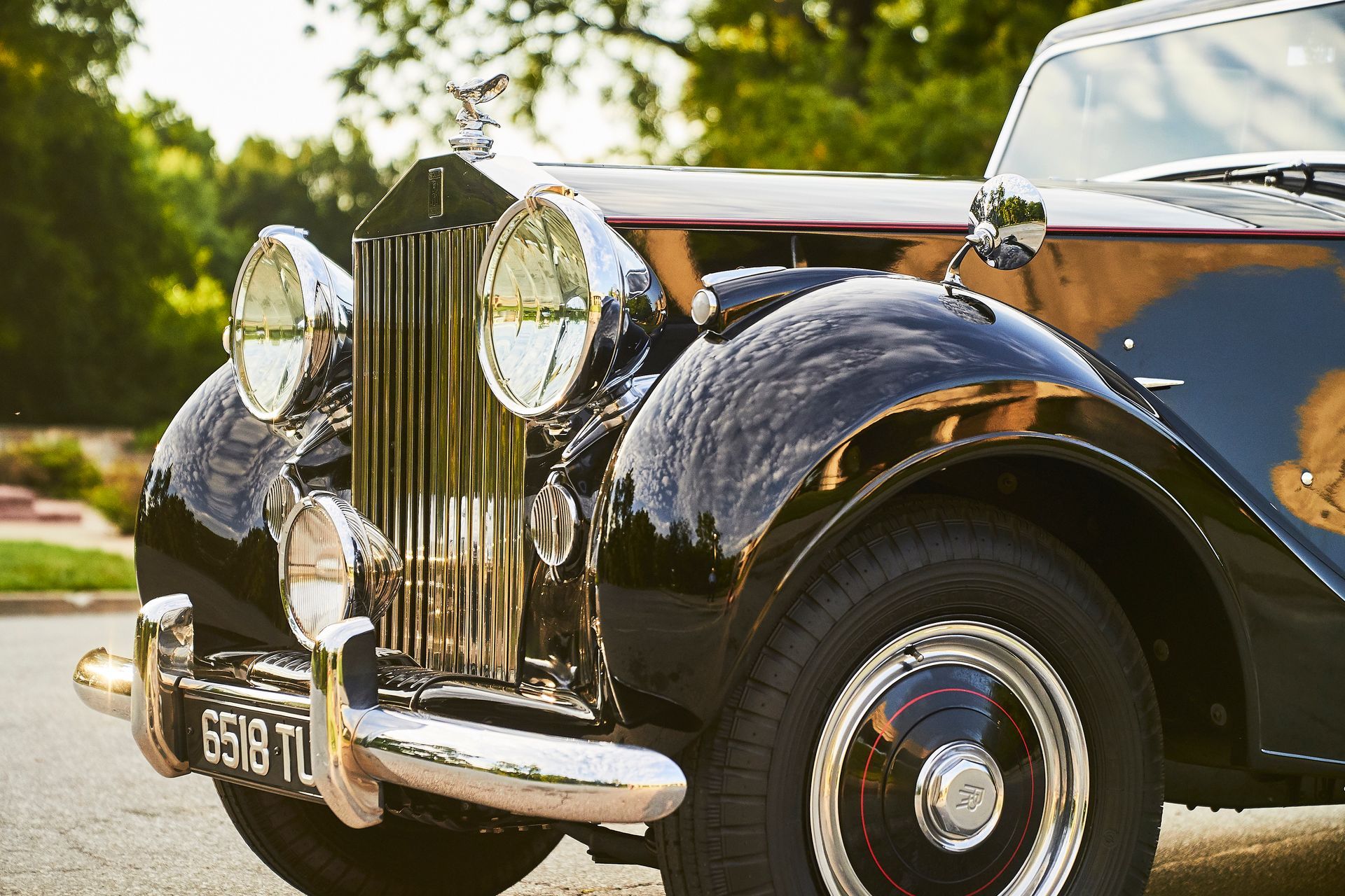 A black rolls royce is parked on the side of the road.