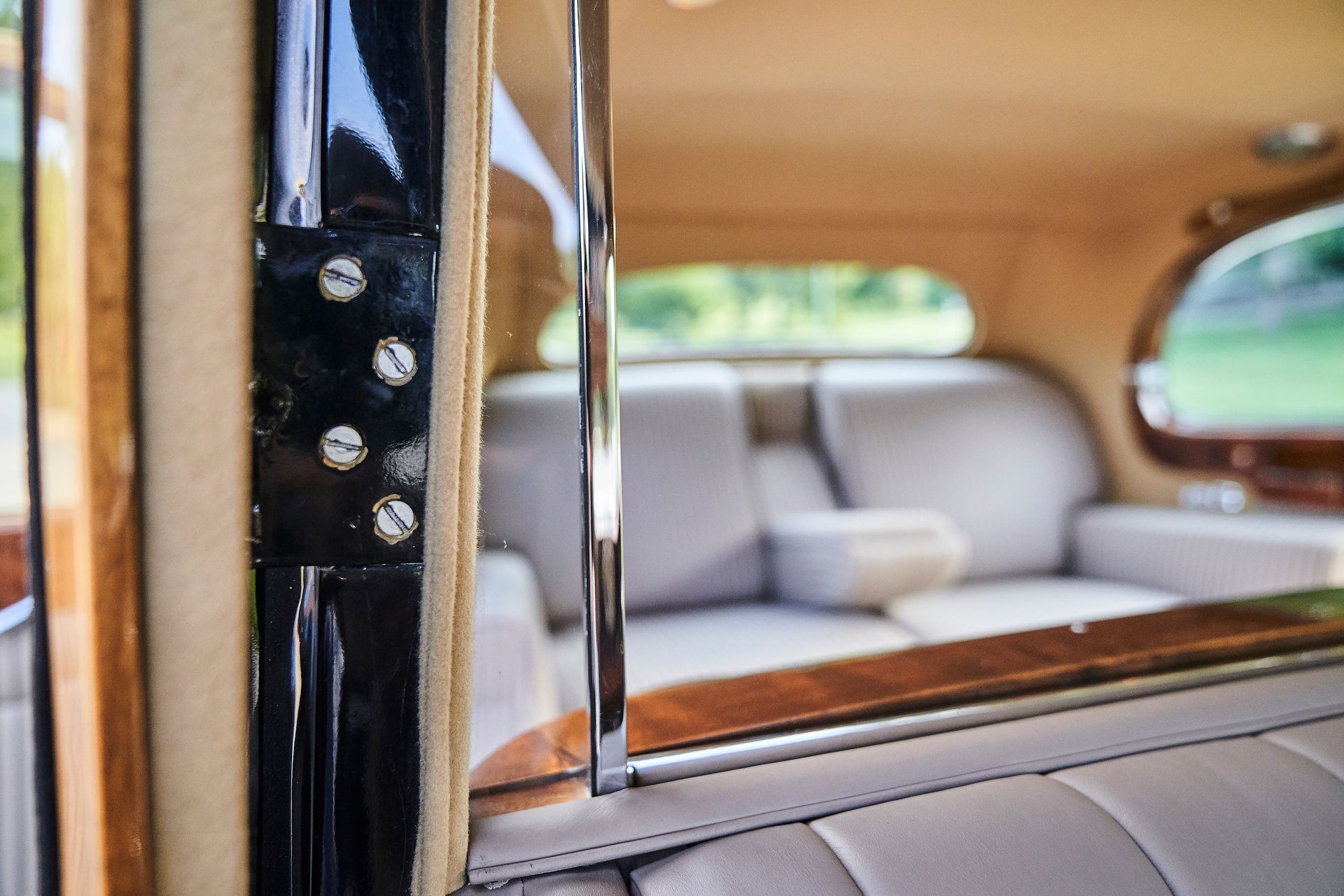 The inside of a car with a couch and a window.