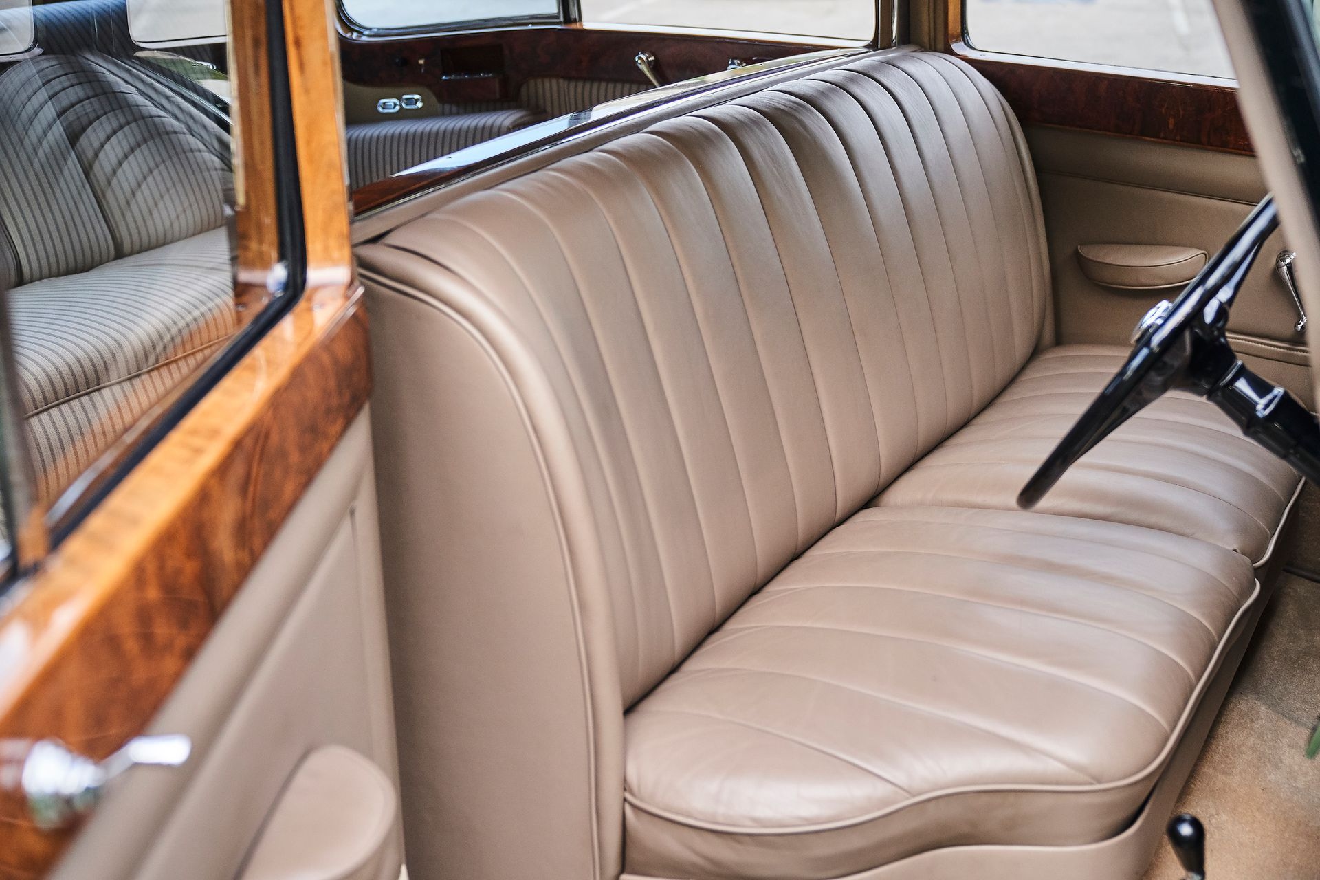 The back seat of a car with a steering wheel