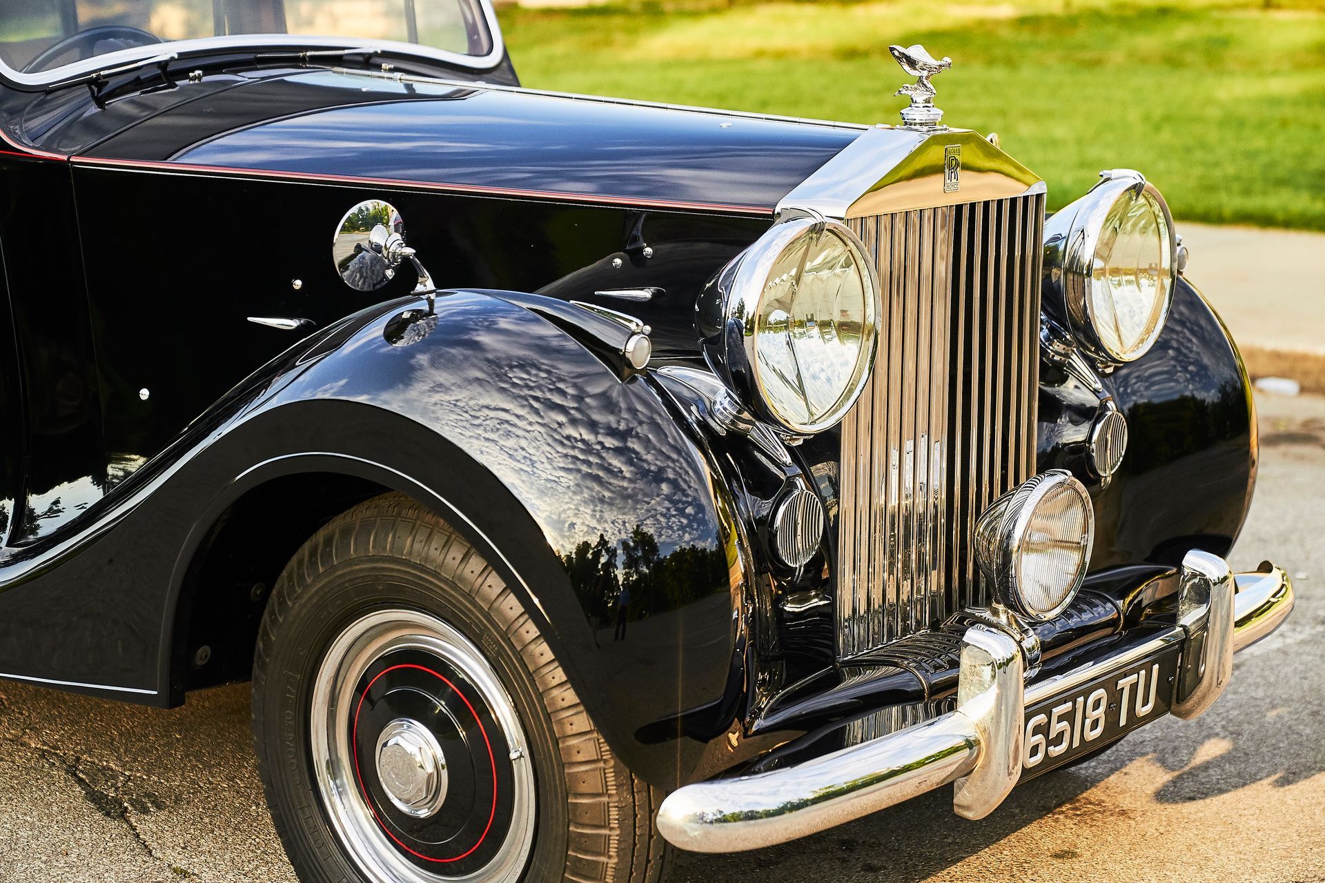 A black rolls royce is parked on the side of the road.