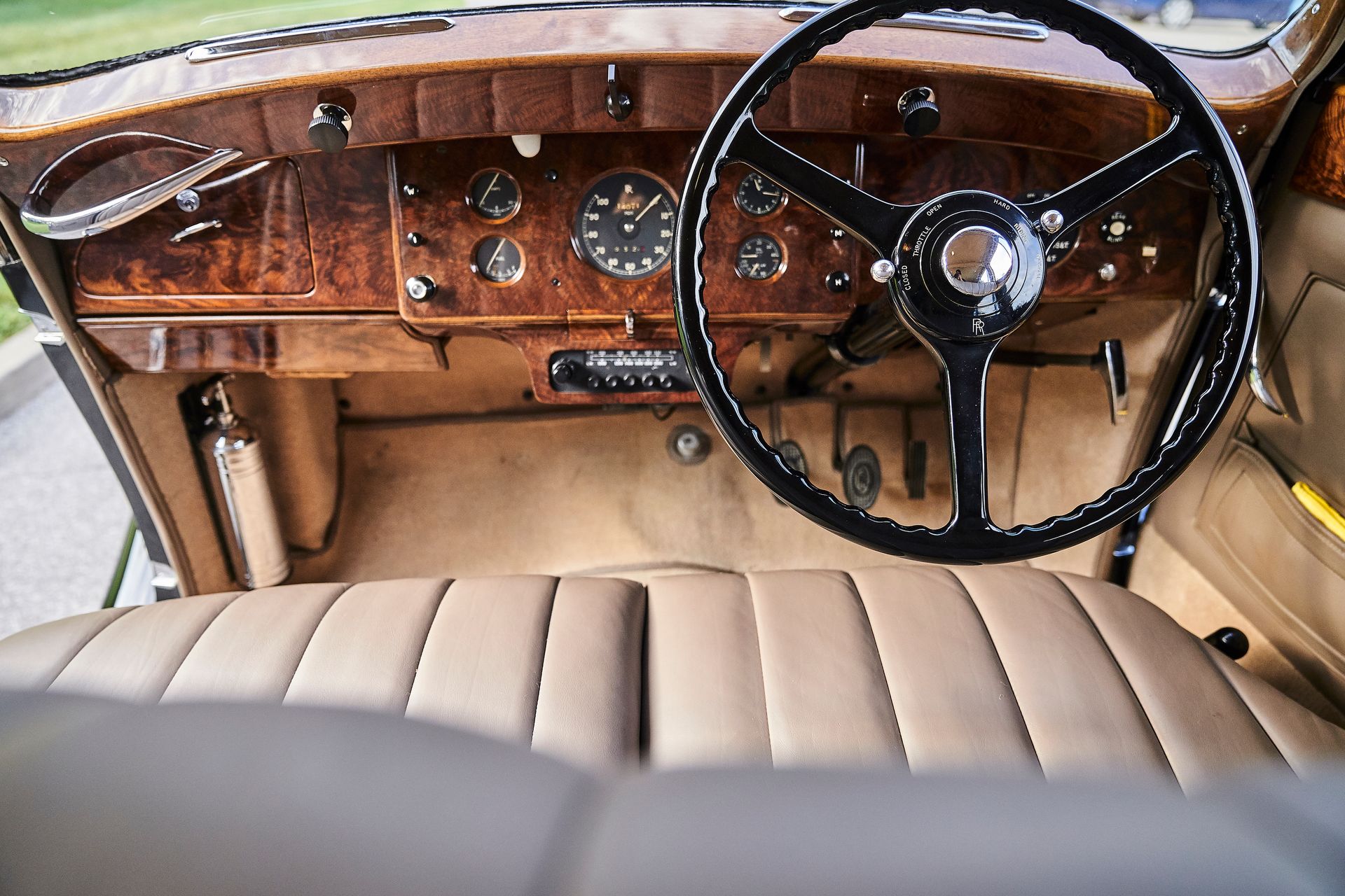 The interior of an old car with a steering wheel and dashboard.