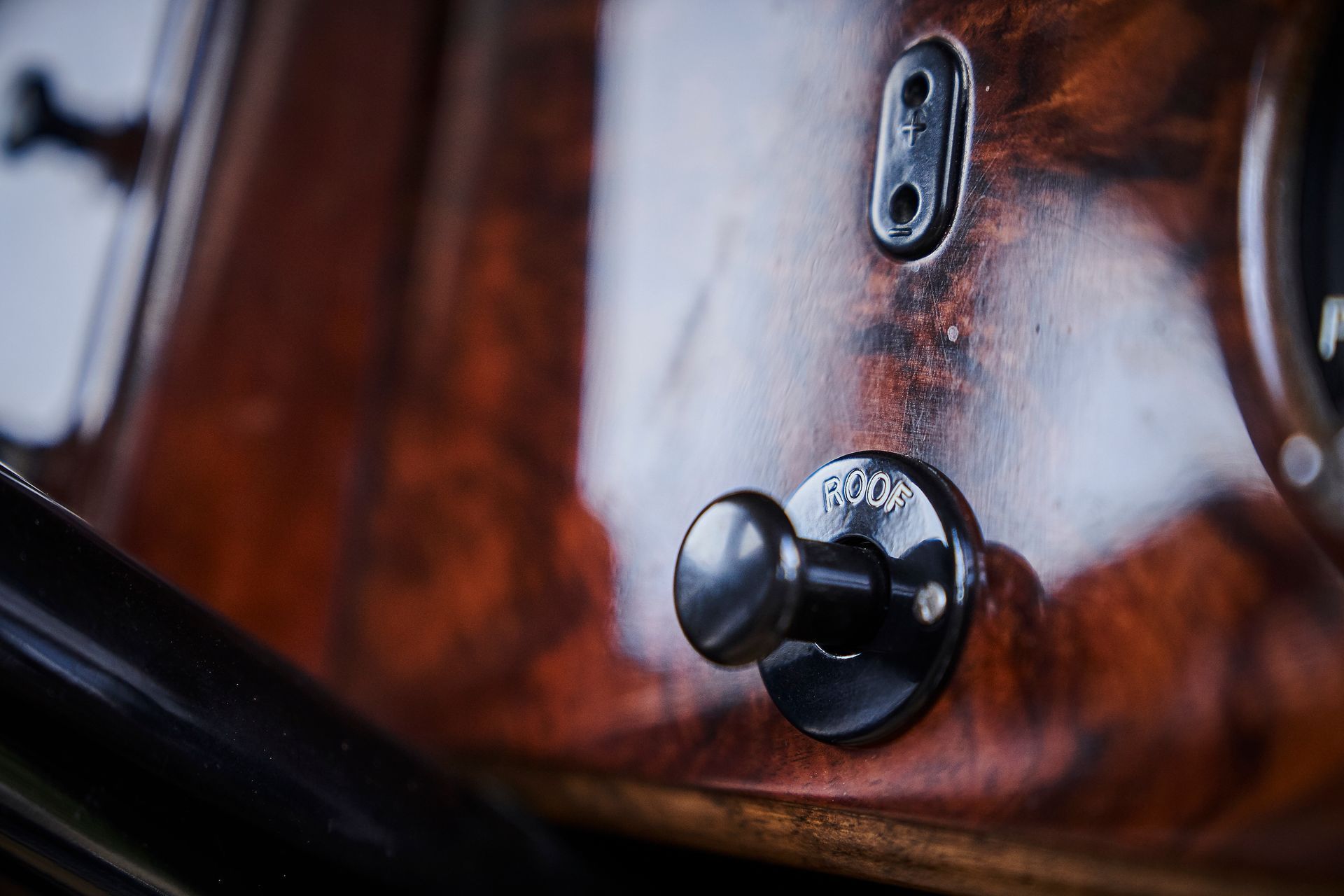 A close up of a toggle switch on a wooden surface.
