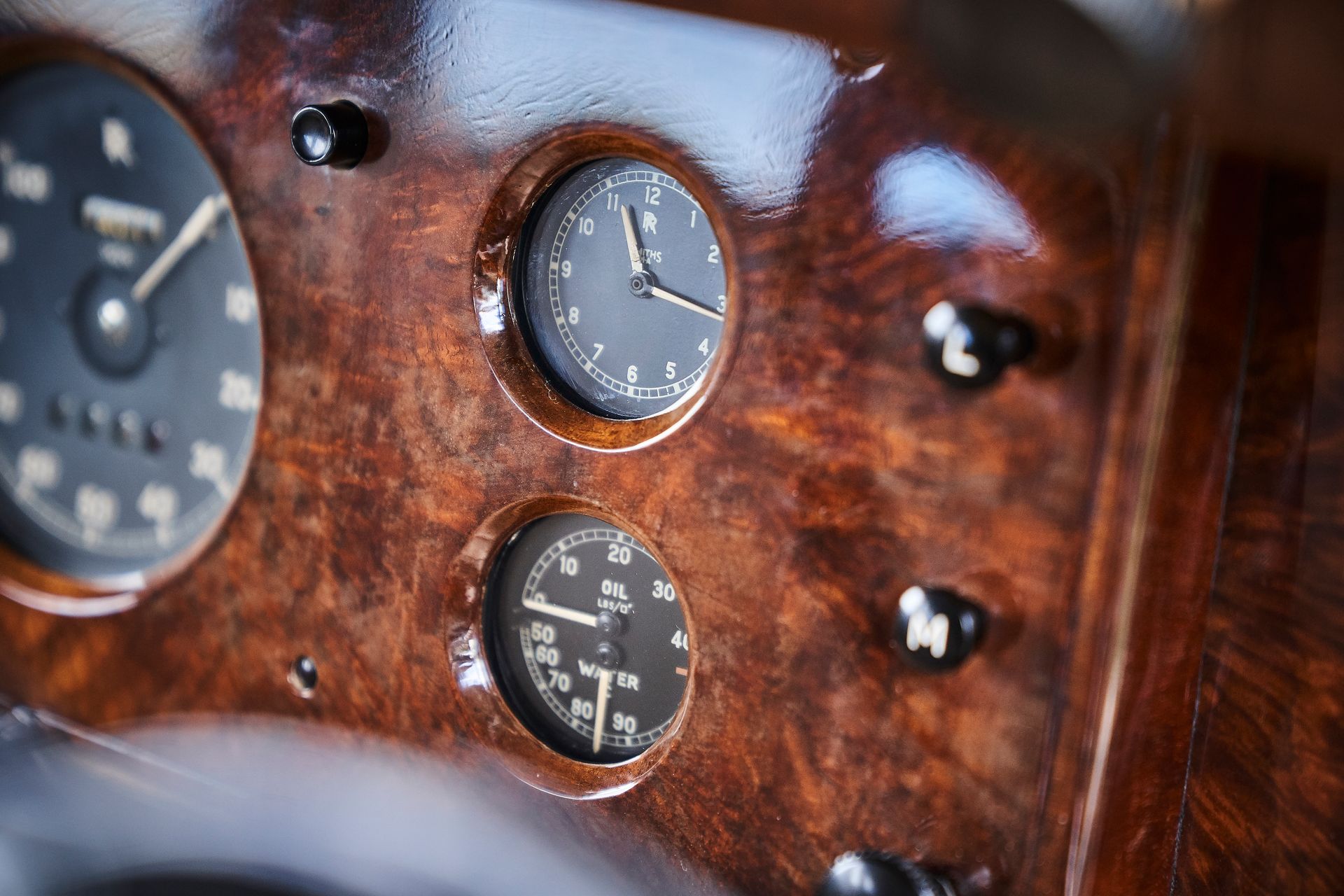 A close up of a wooden dashboard with a clock on it