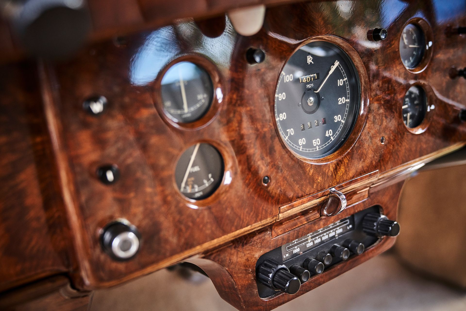 A close up of a wooden dashboard of an old car.