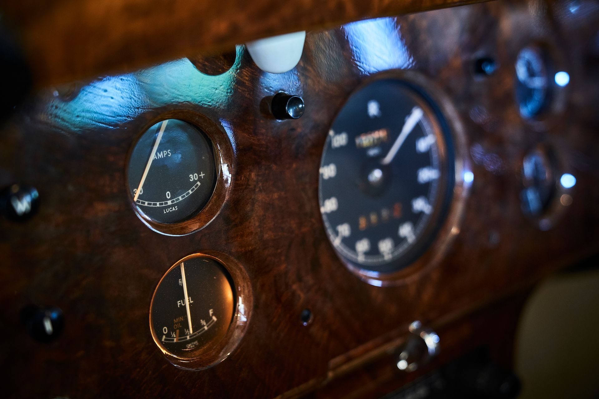 A close up of a car dashboard with a clock and other gauges.
