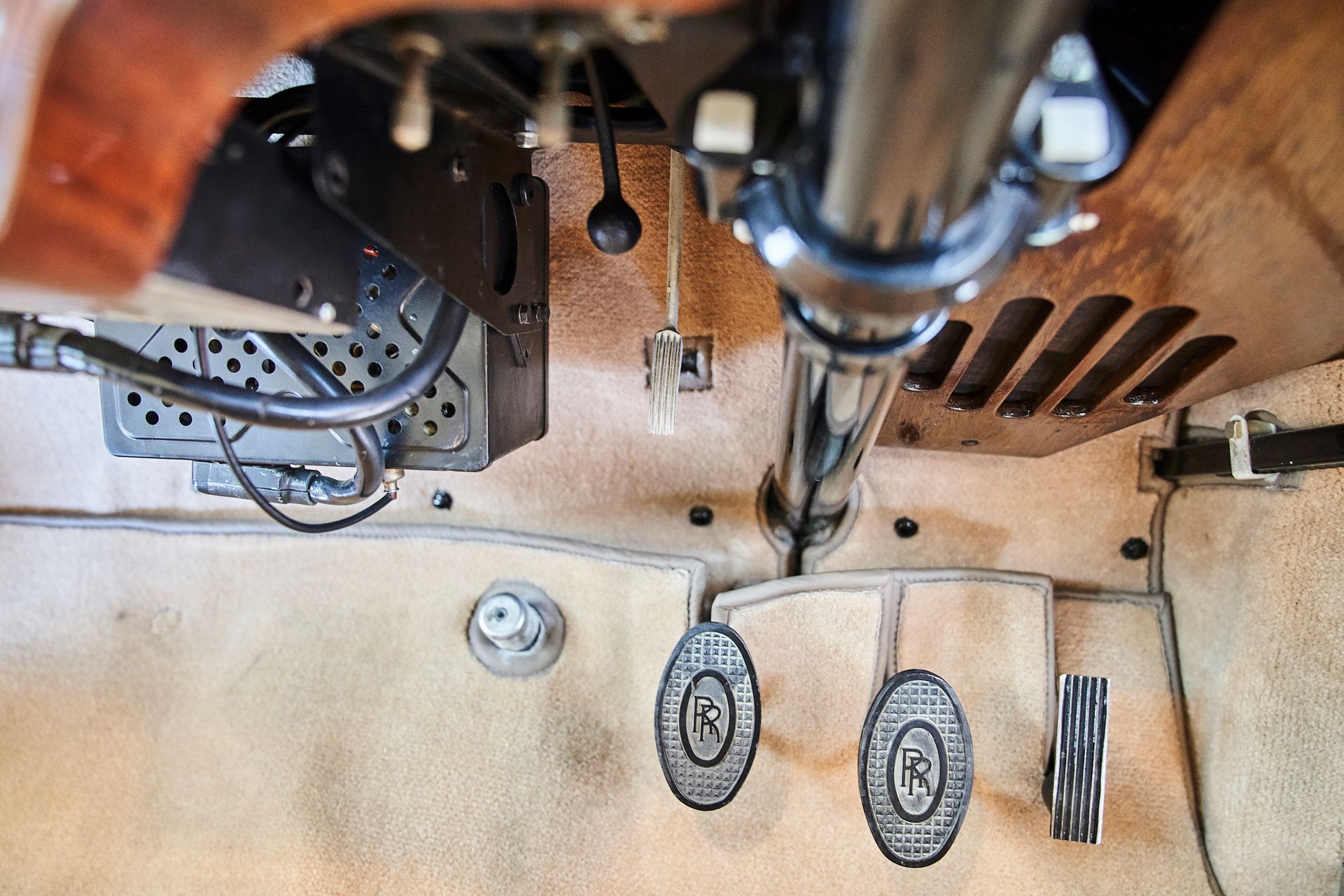 A close up of a car 's steering wheel and brake pedals.