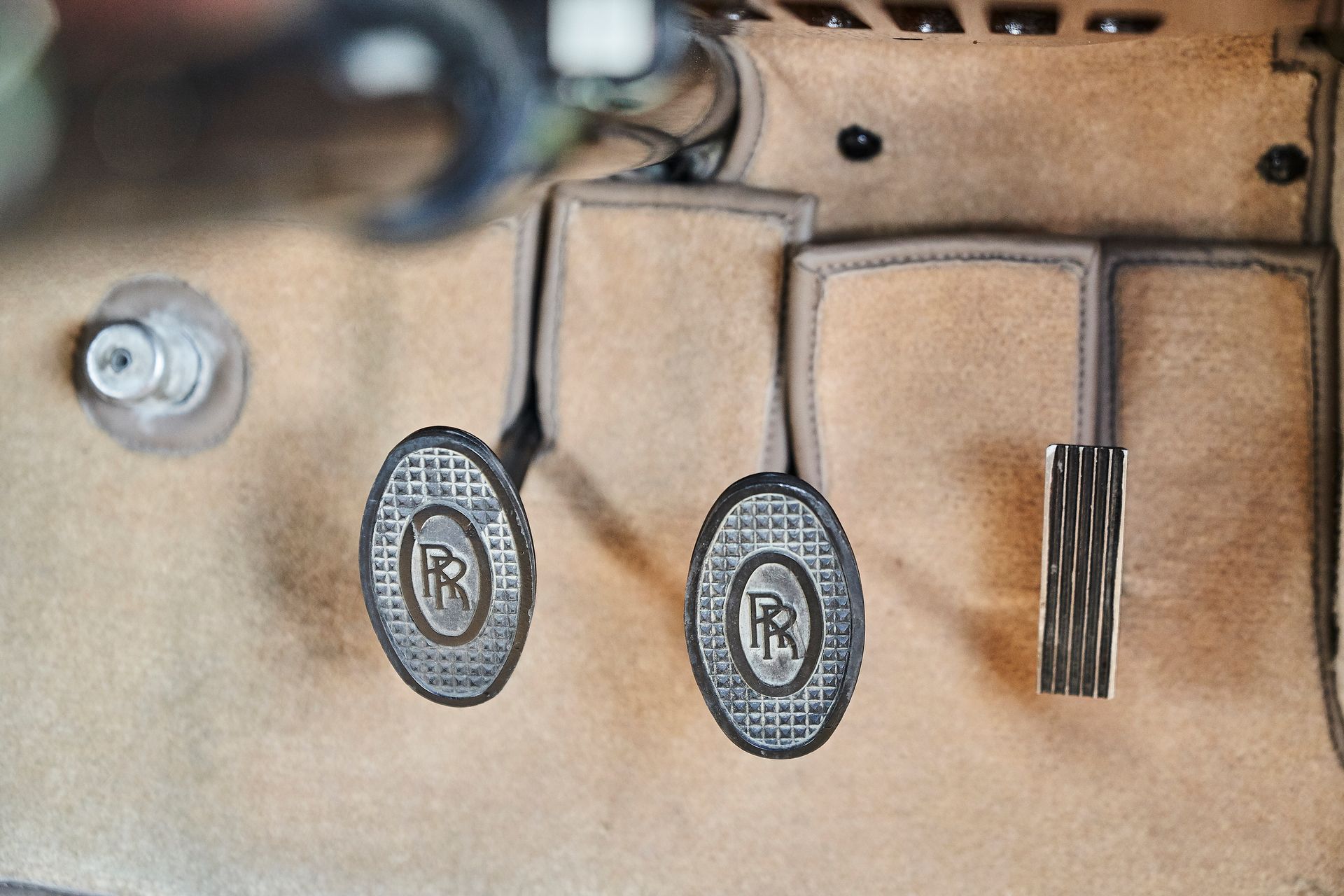 A close up of a pair of brake pedals on a car.