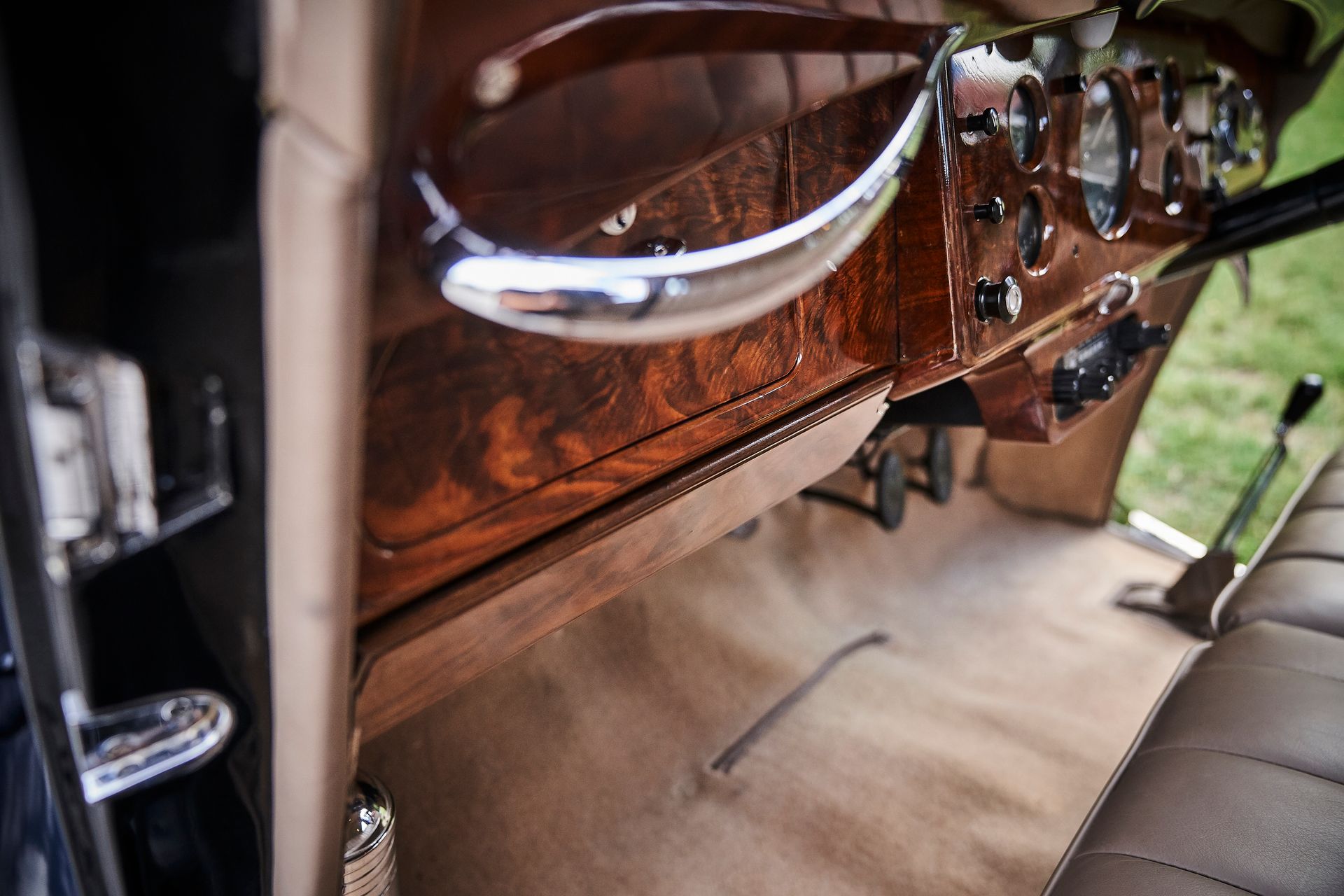 A close up of the interior of an old car with a wooden dashboard.
