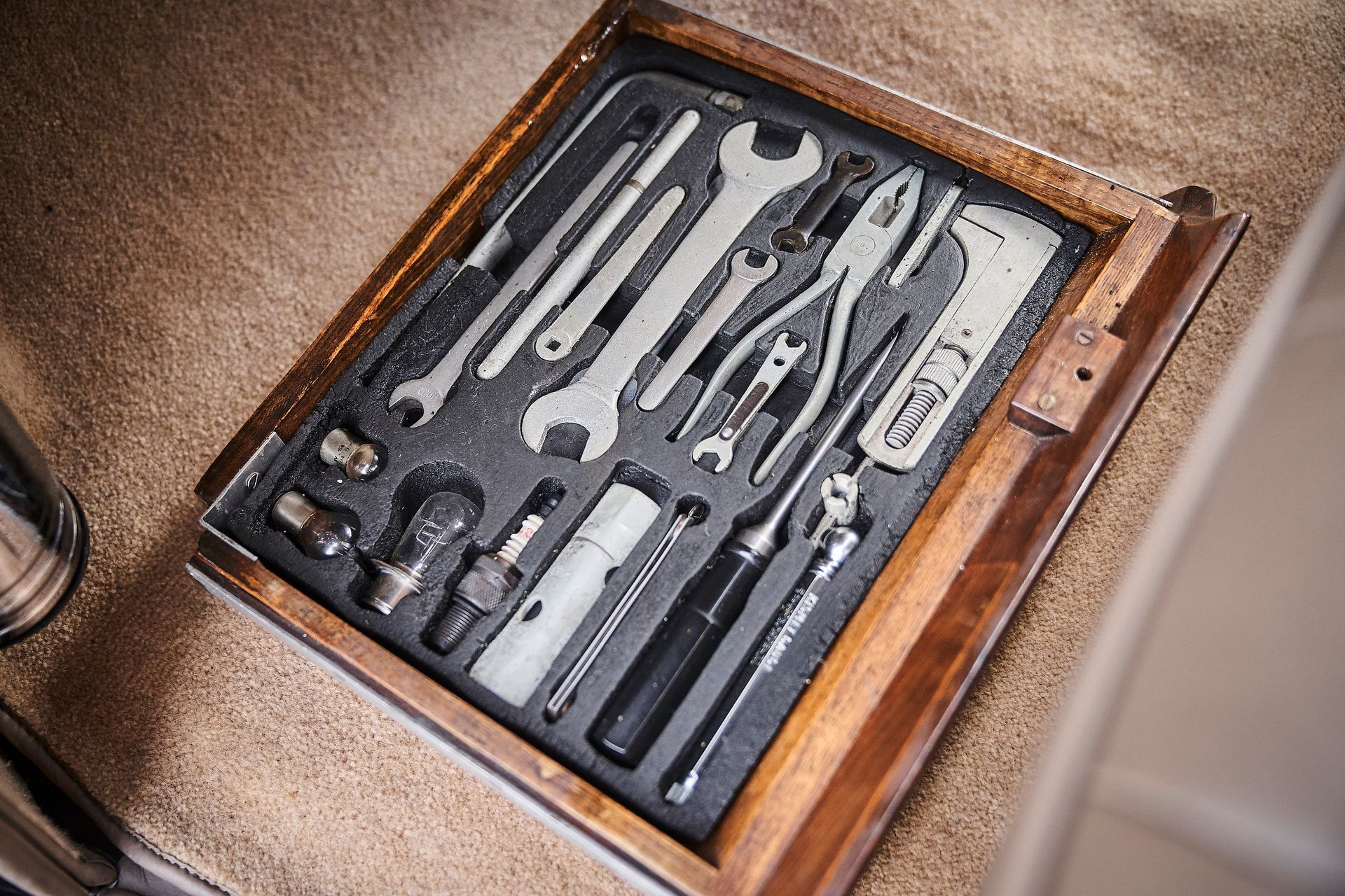 A wooden box filled with a variety of tools.