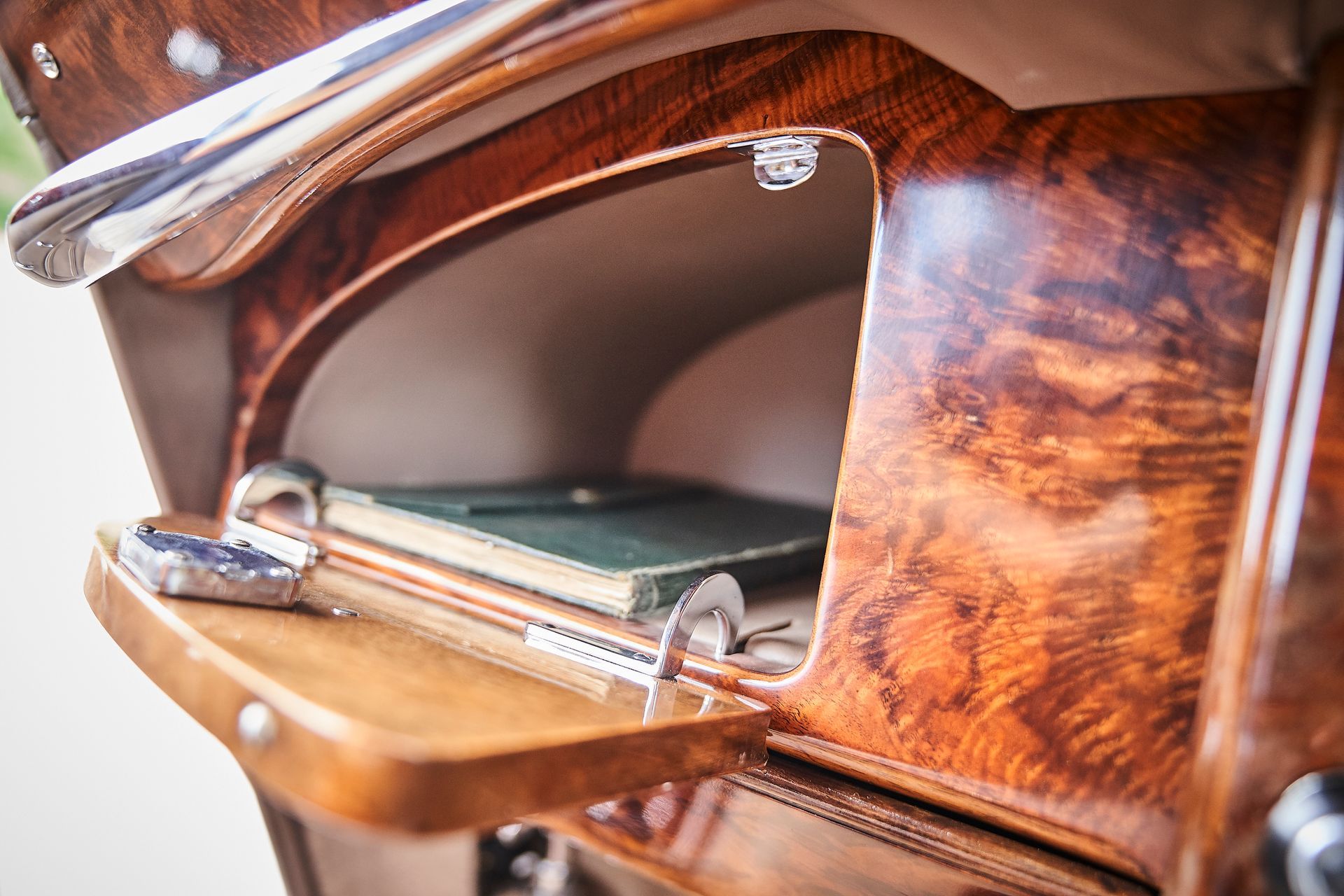 A close up of a wooden trunk in a car with a book in it.