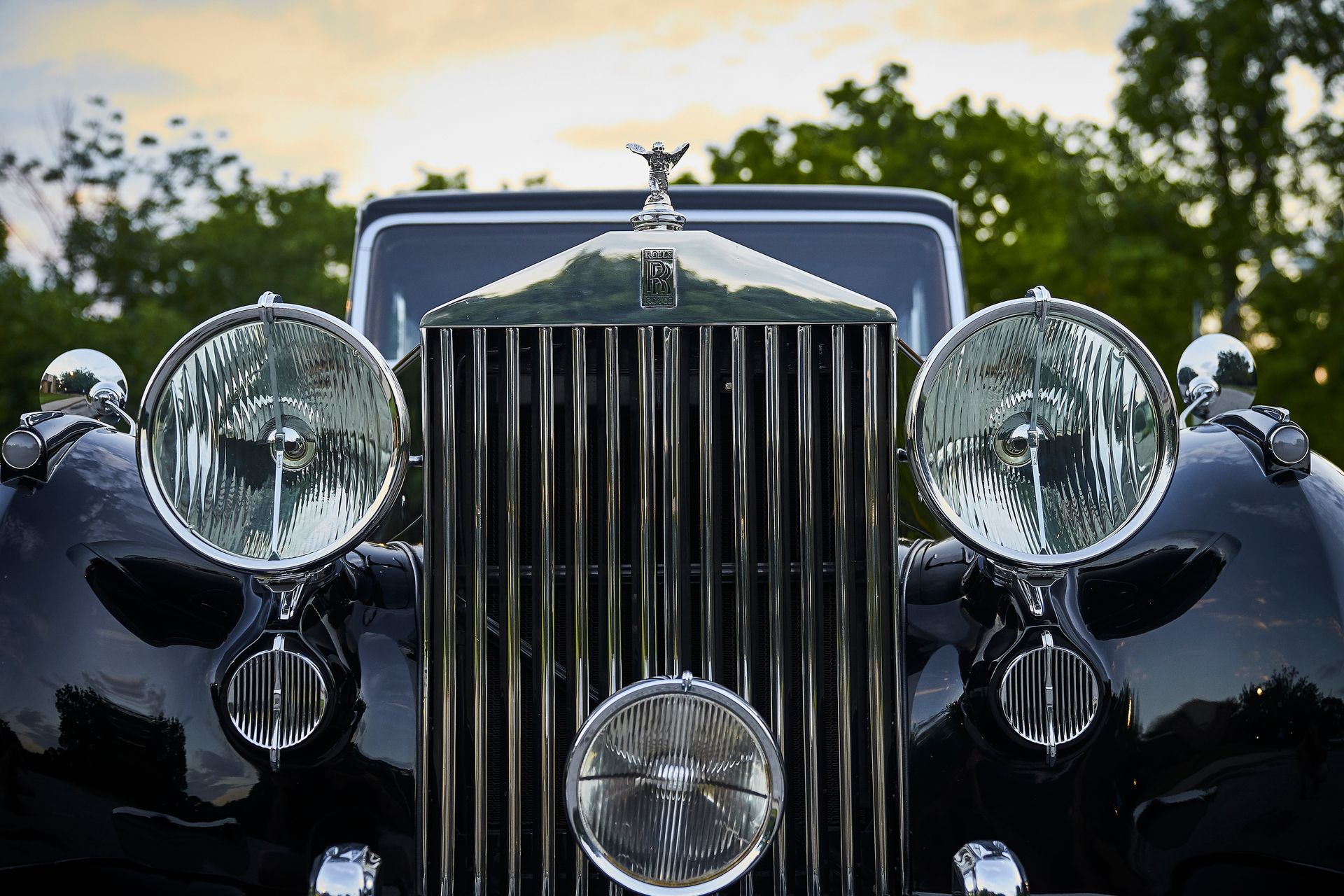A close up of the front of a black rolls royce car.