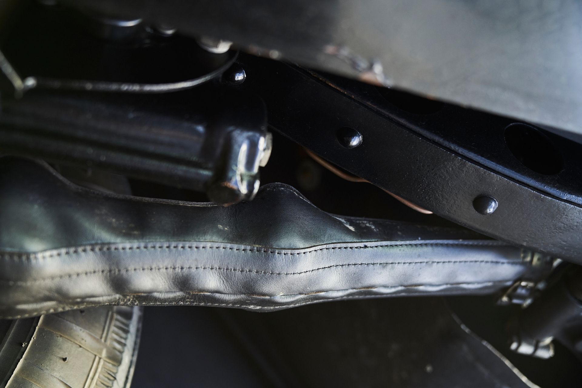 A close up of a black item with a tire in the background