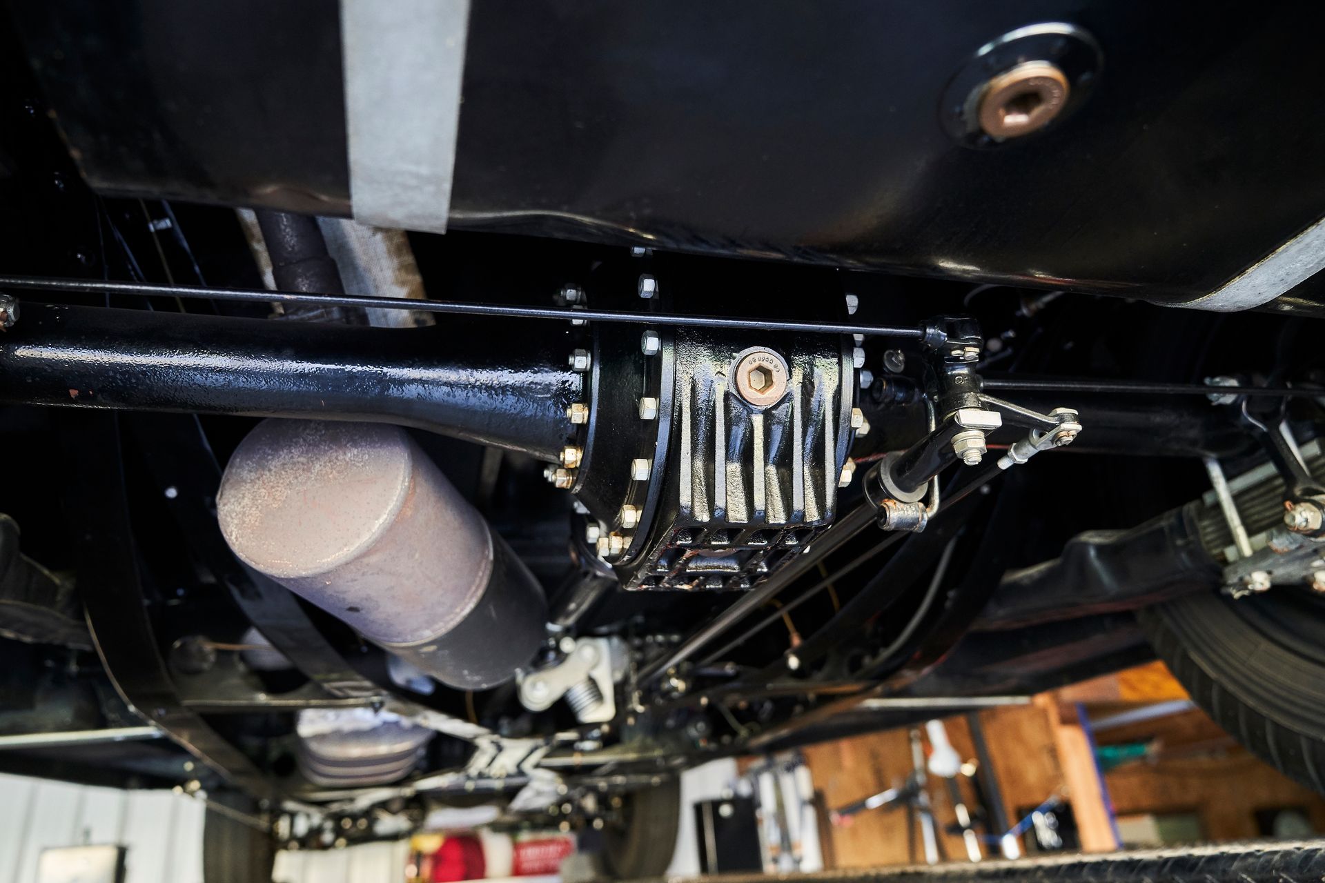 A close up of the underside of a car in a garage.