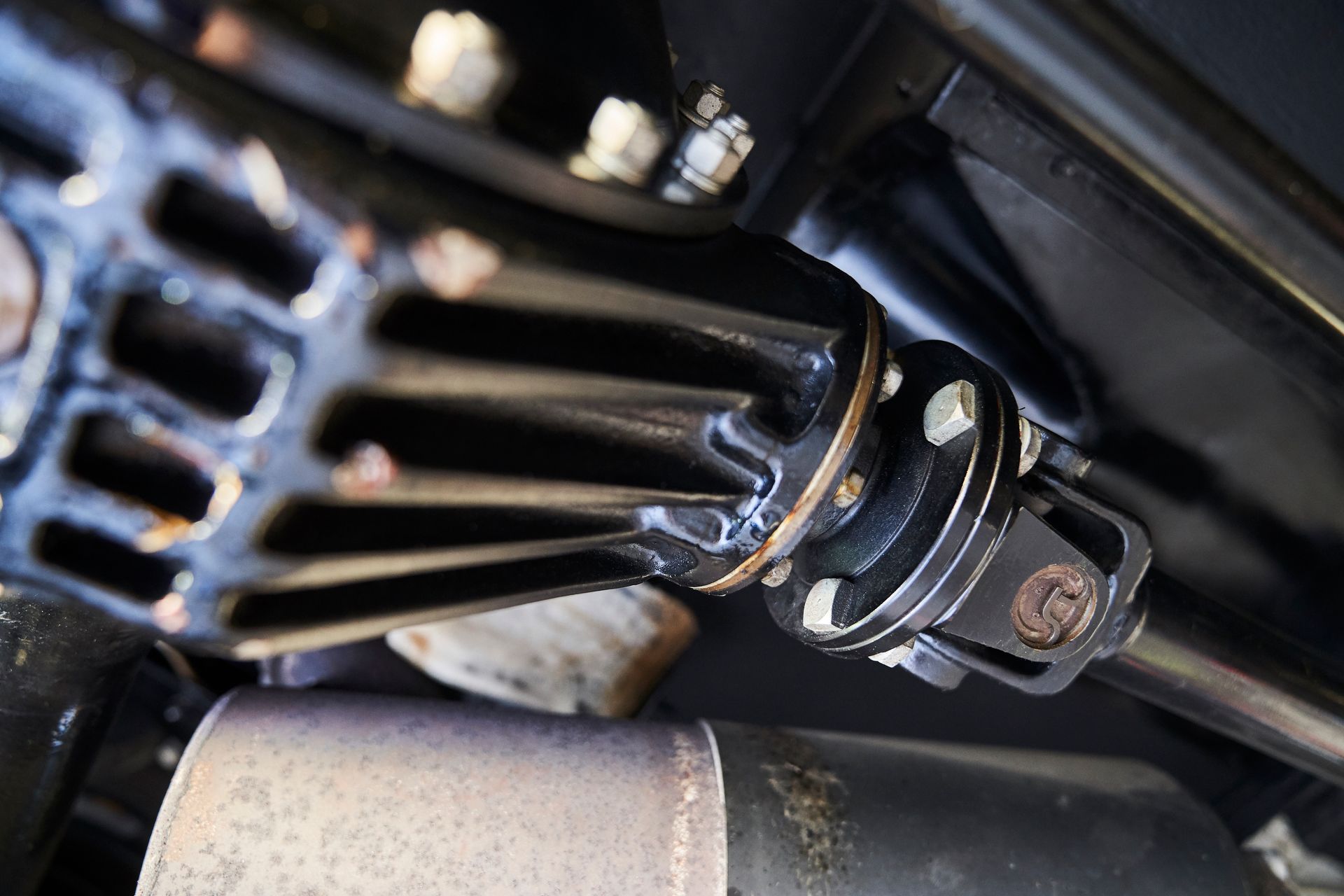 A close up of a rear drive shaft on a car.
