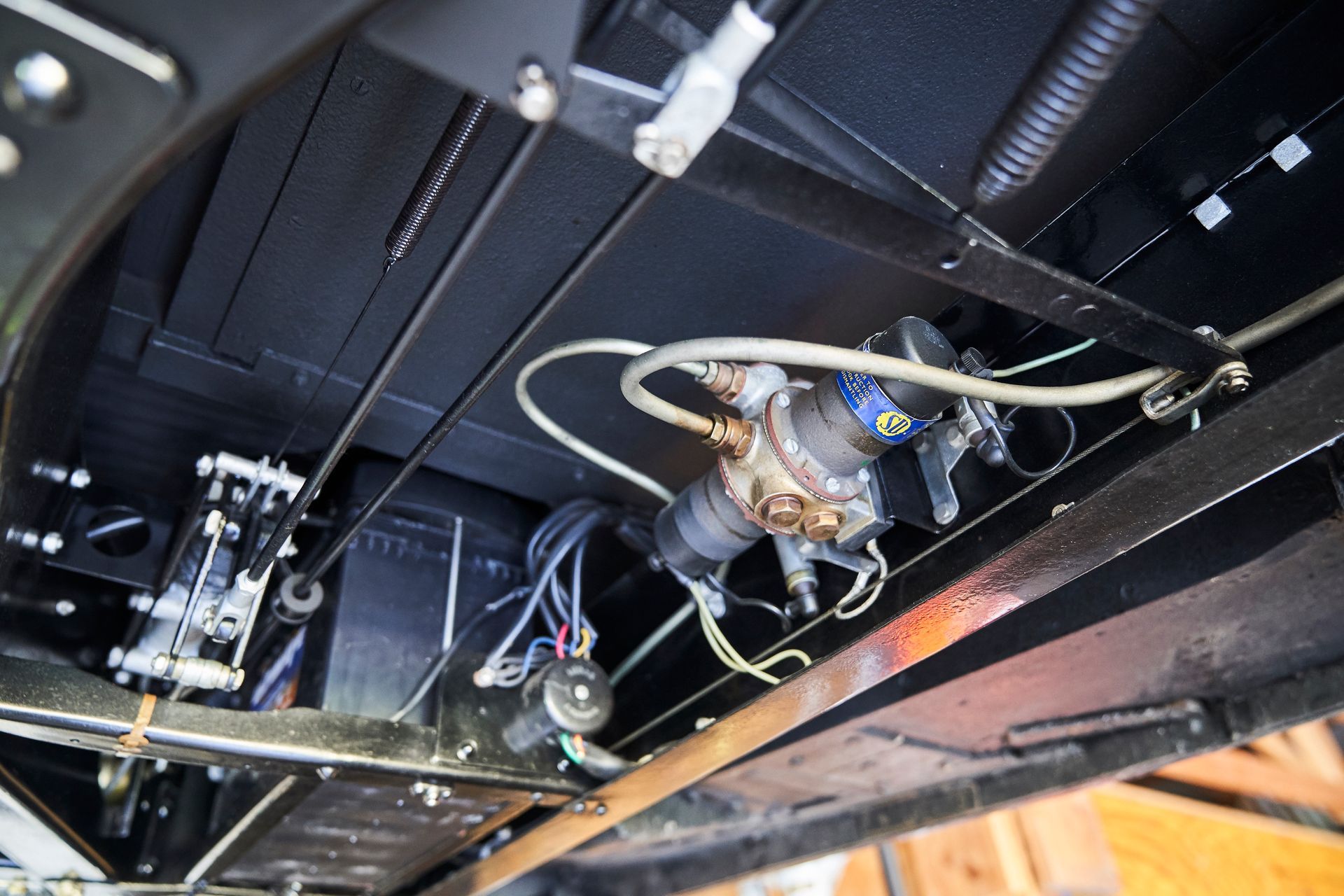 A close up of the underside of a car with a lot of wires and pipes.