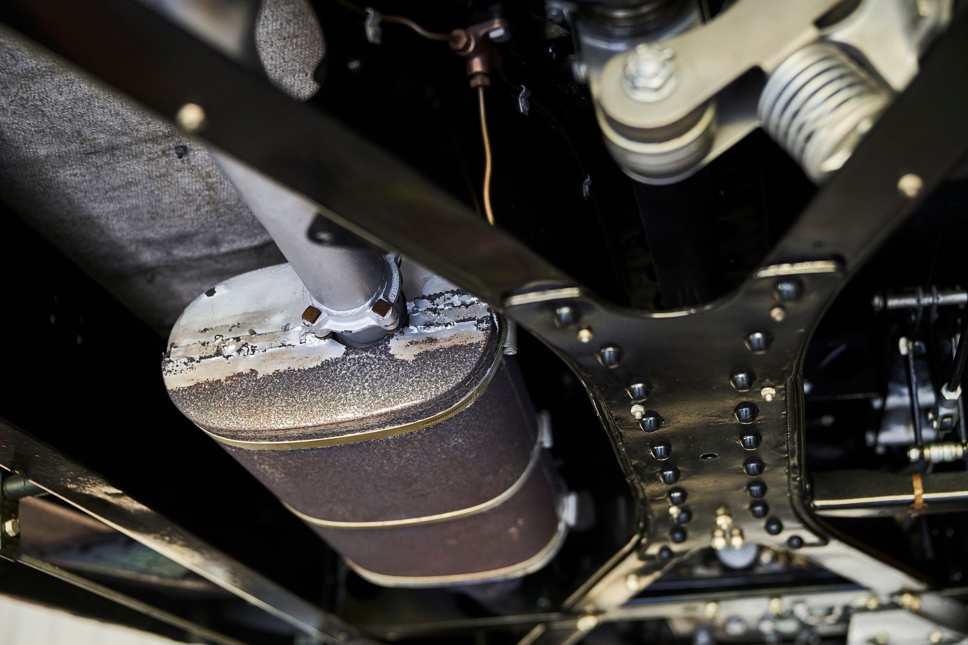 A close up of the underside of a car with a exhaust pipe.