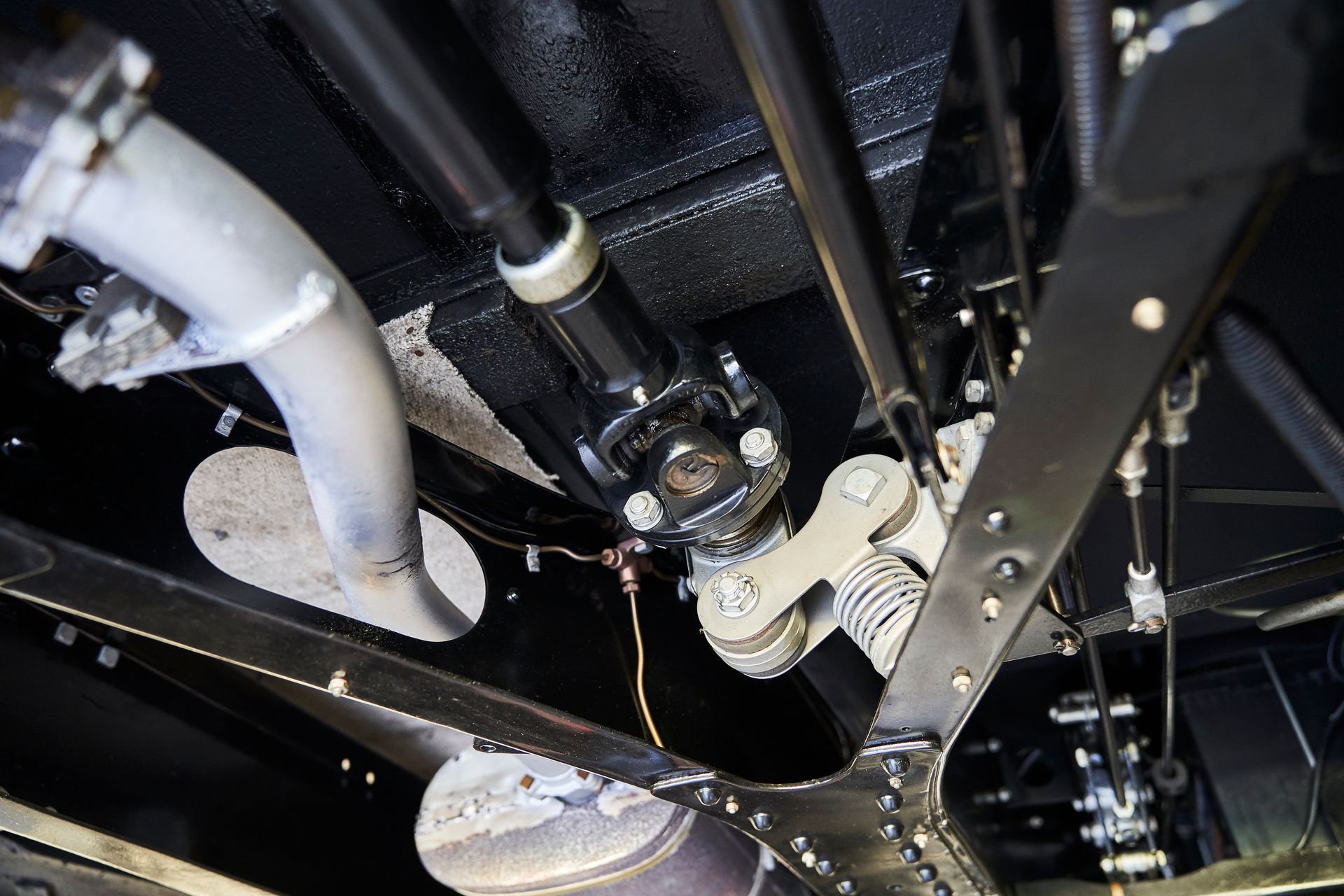 A close up of the underside of a car with a exhaust pipe.