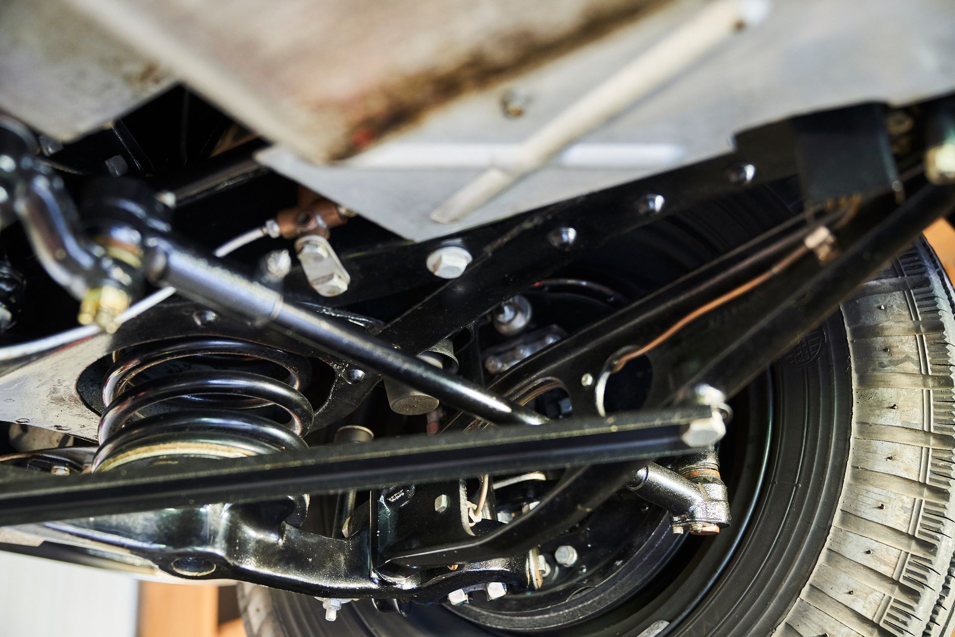 A close up of the underside of a car with a tire.