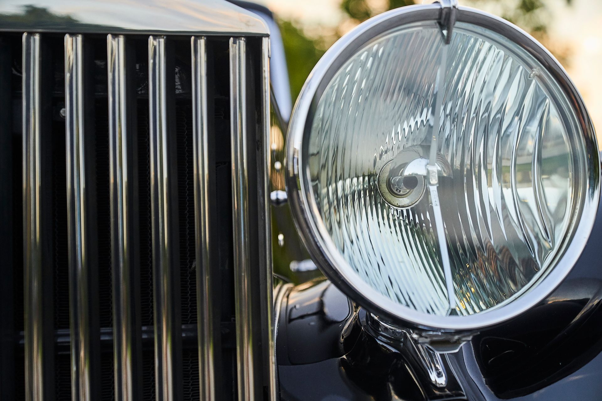 A close up of a car 's headlight and grille.
