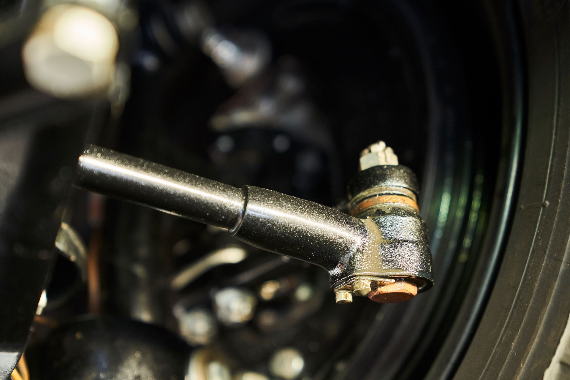 A close up of a tie rod on a car wheel