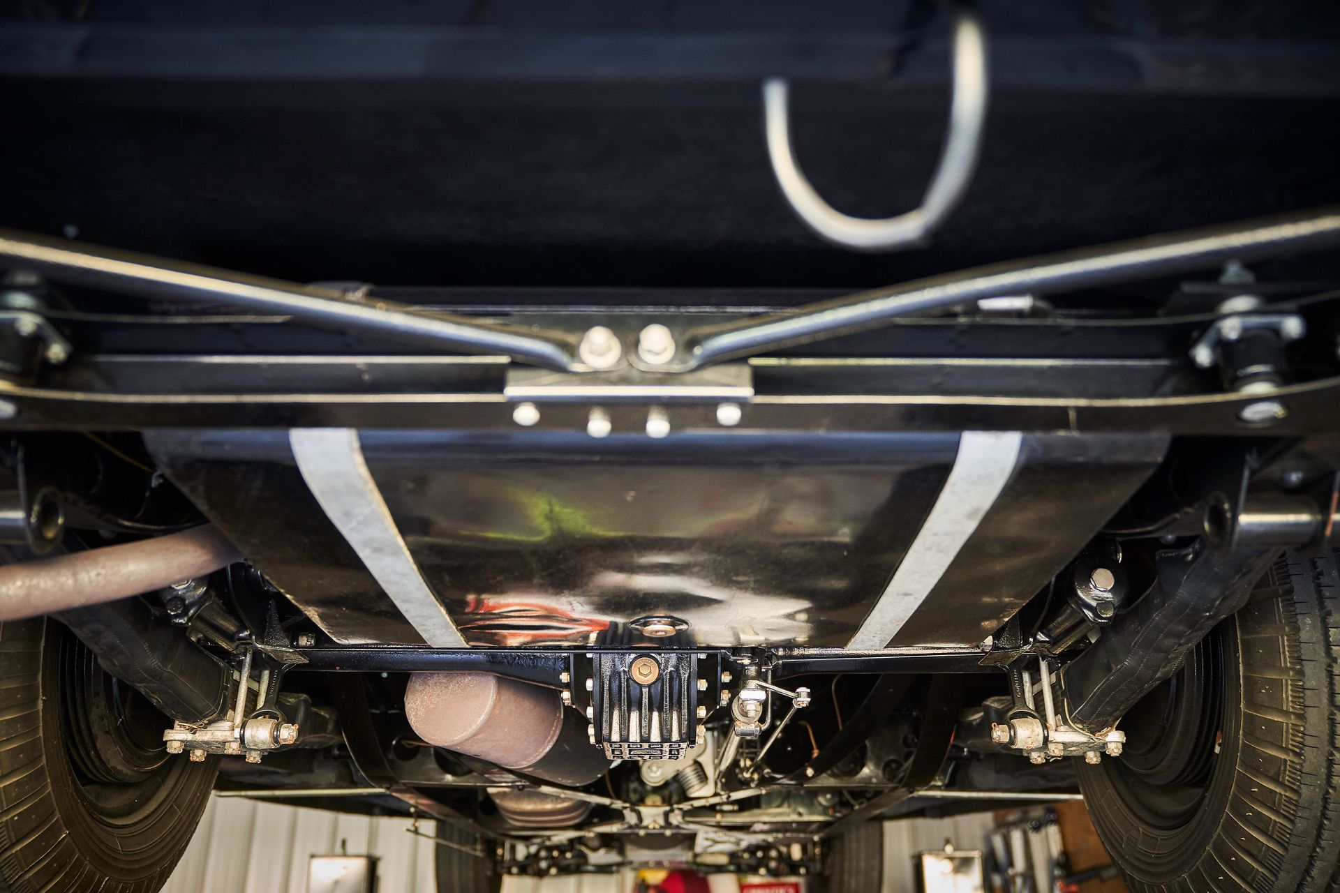 A close up of the underside of a car in a garage.