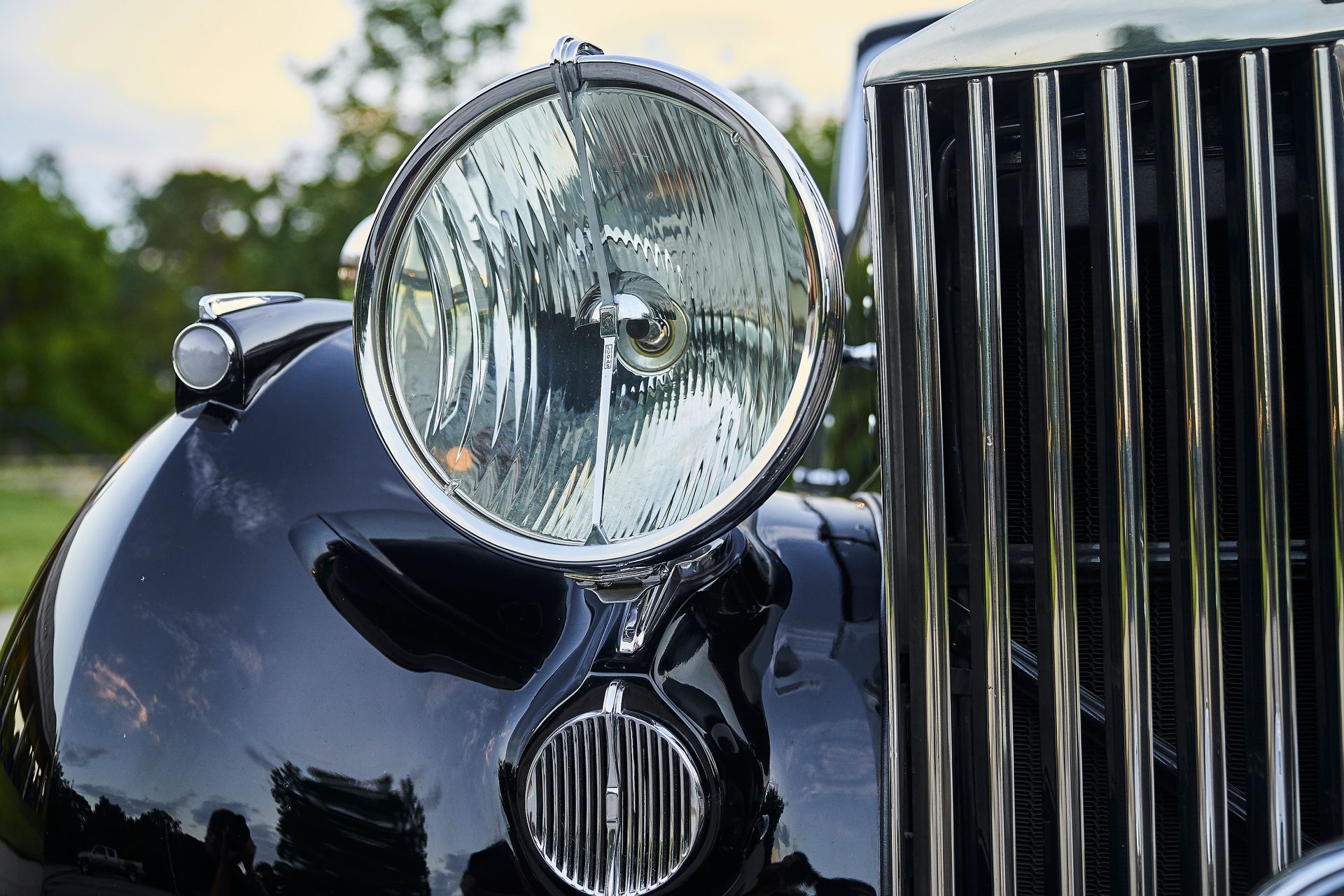 A close up of a car 's headlight and grille