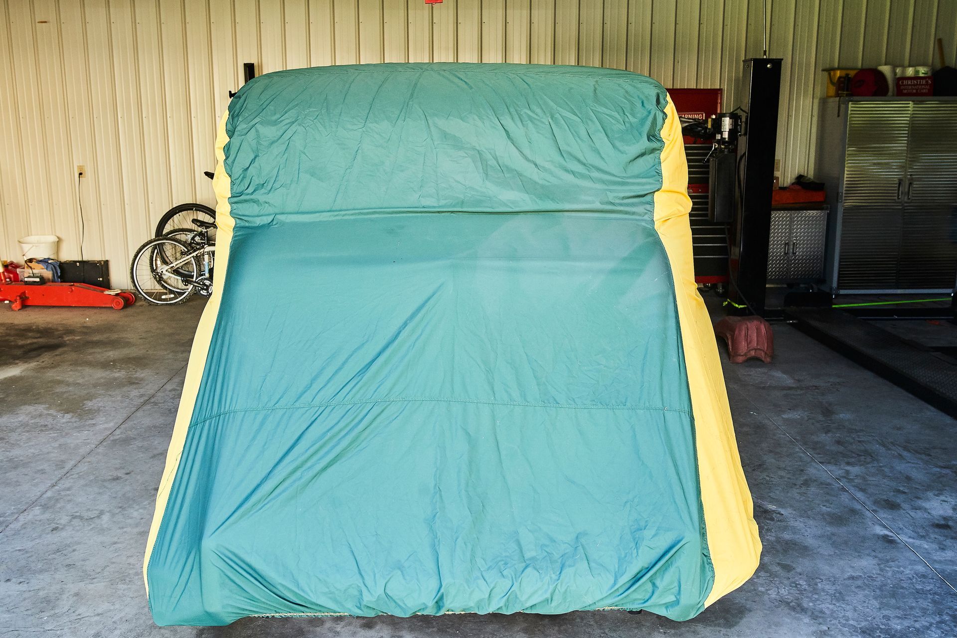 A green and yellow tent is sitting in a garage