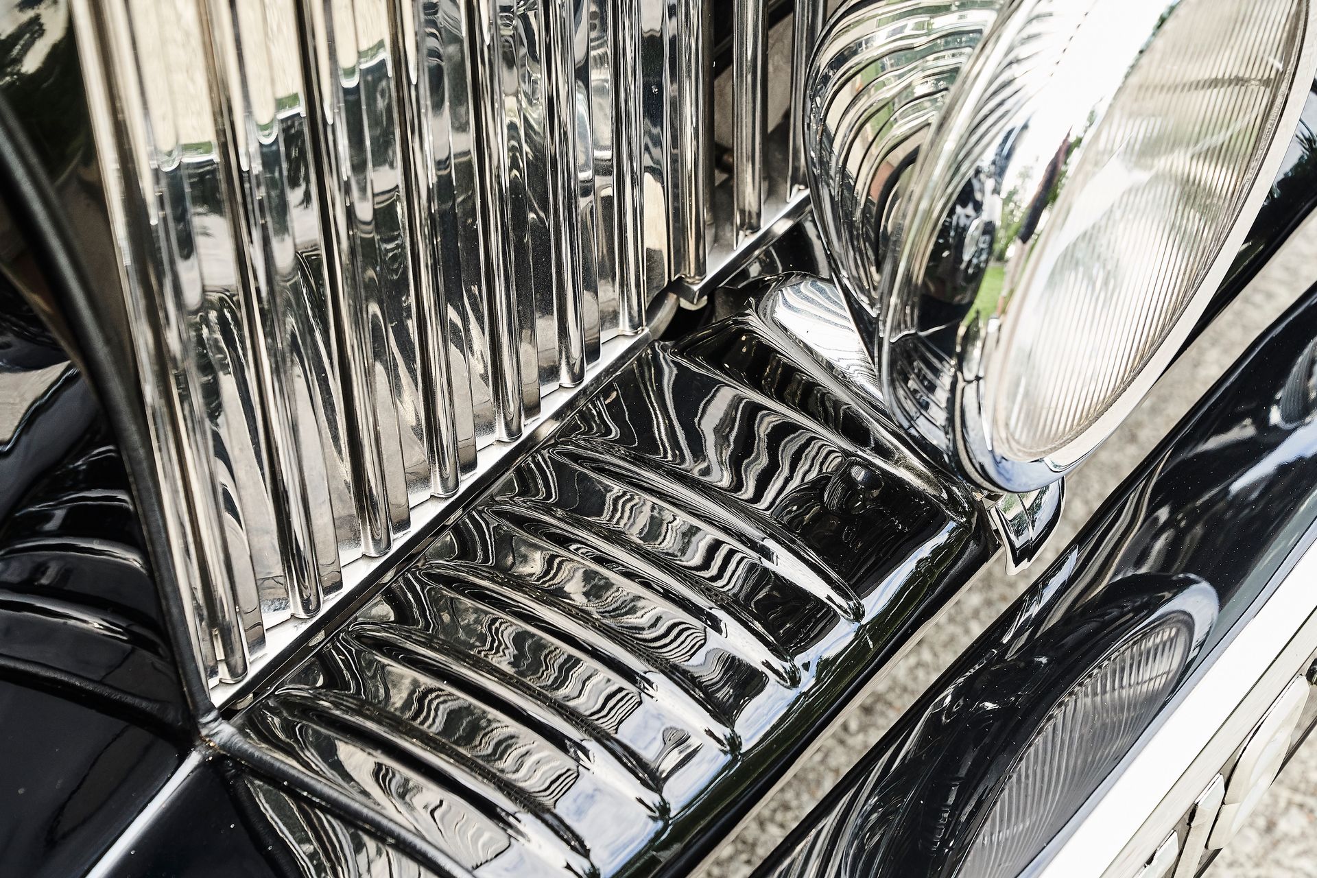 A close up of a car 's headlight and grille