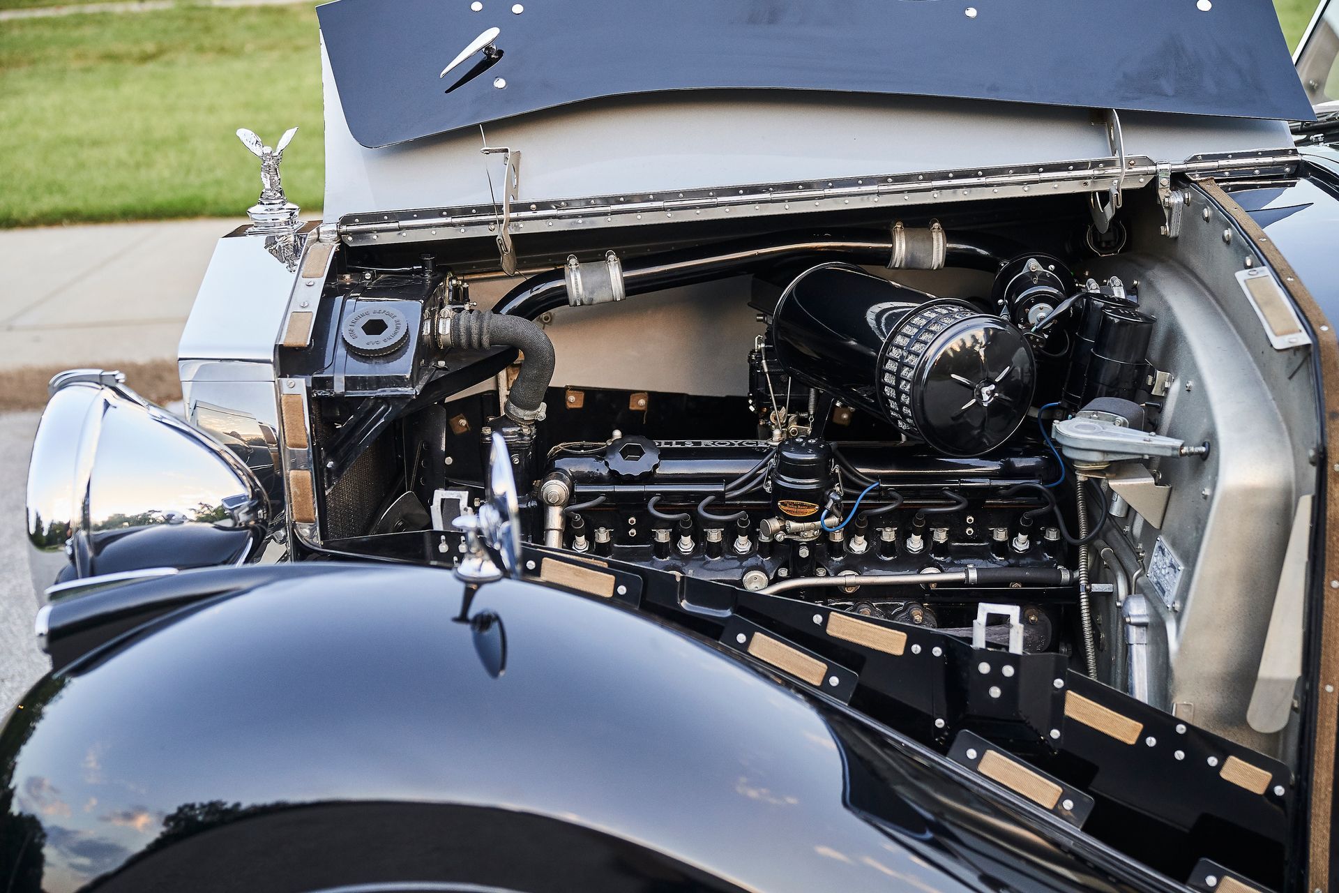A black car with the hood open and the engine visible