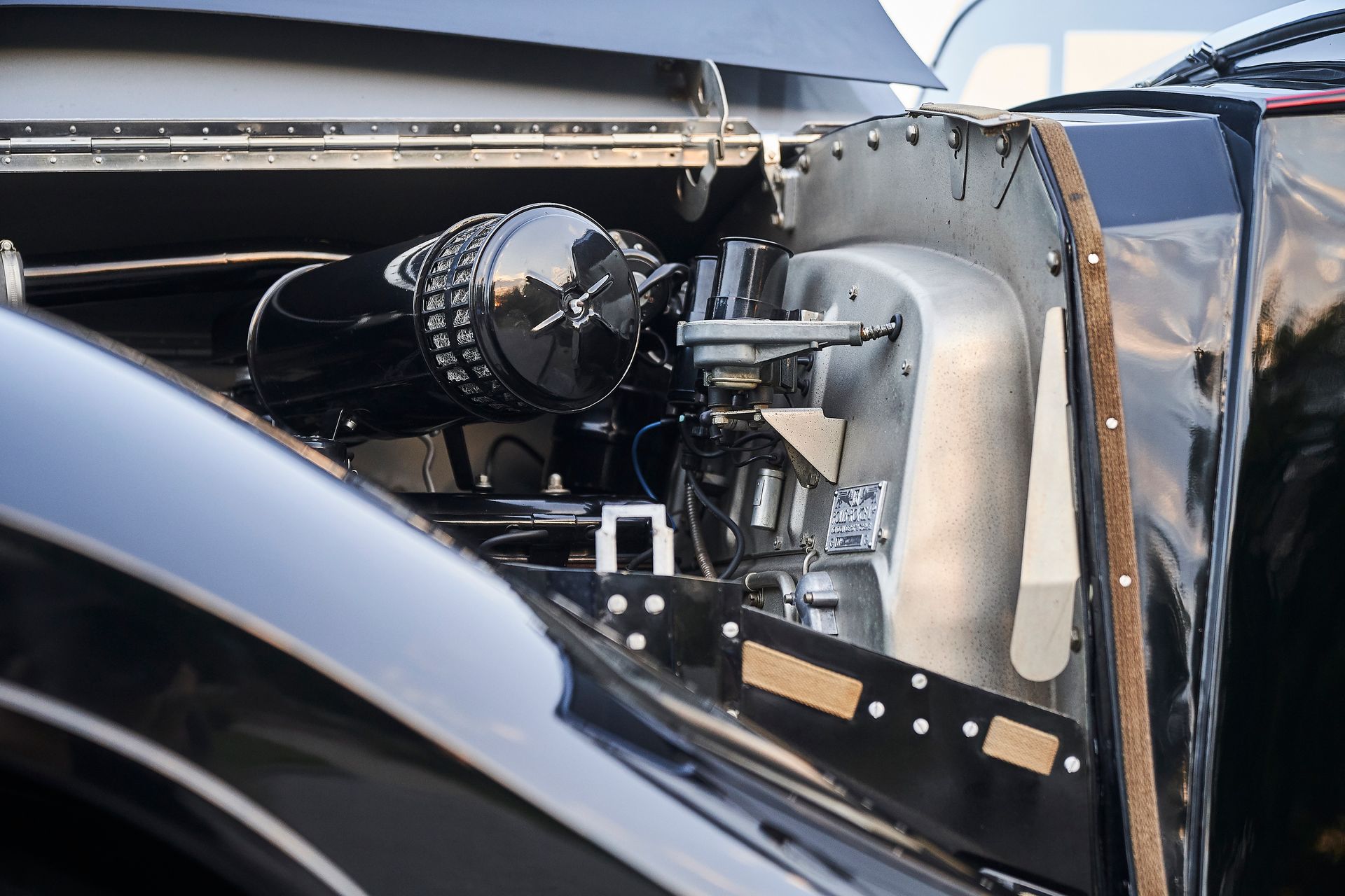 A close up of a car engine with the hood open